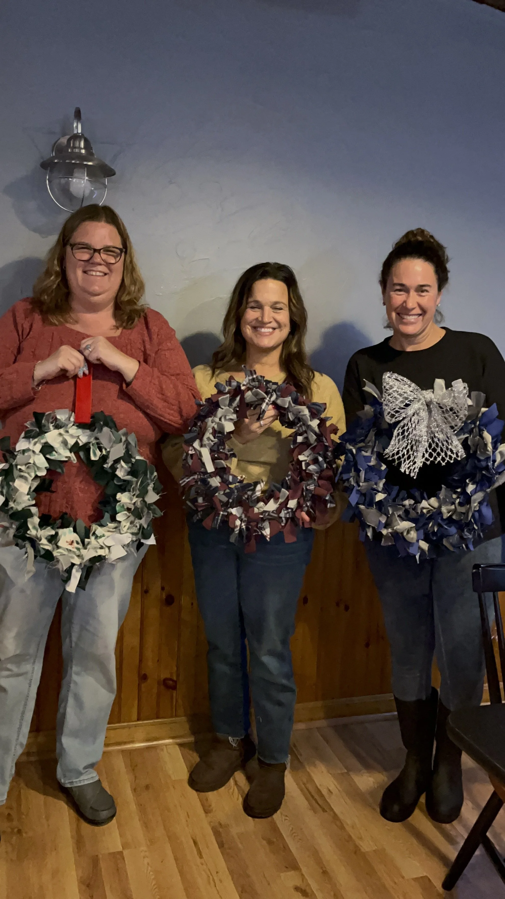 3 people holding  upcycled wreath
