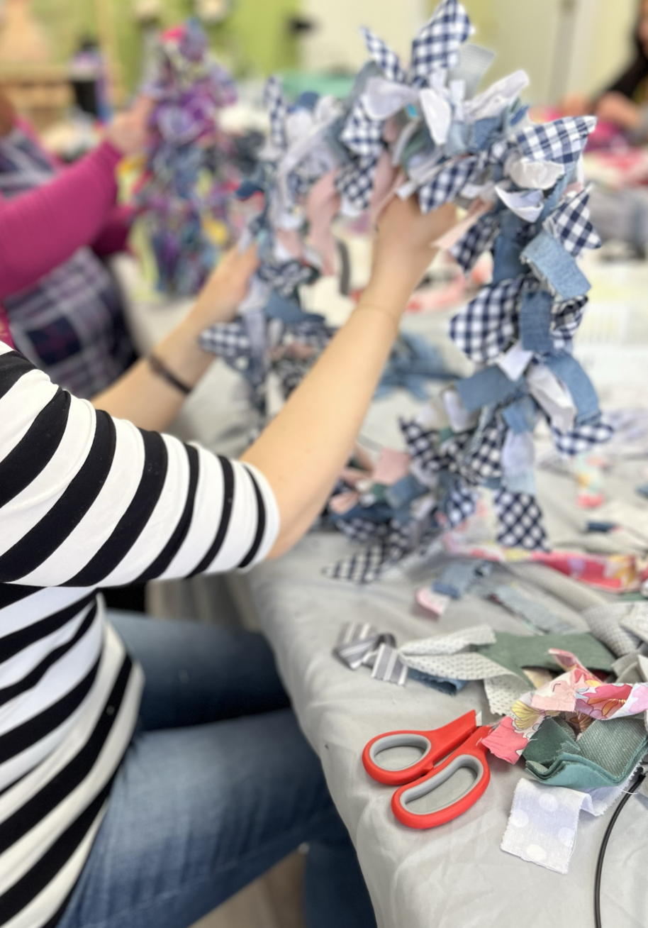 holding wreath made from upcycled textiles in a workshop at Slow Craft Co in Nashua NH and greater Boston MA