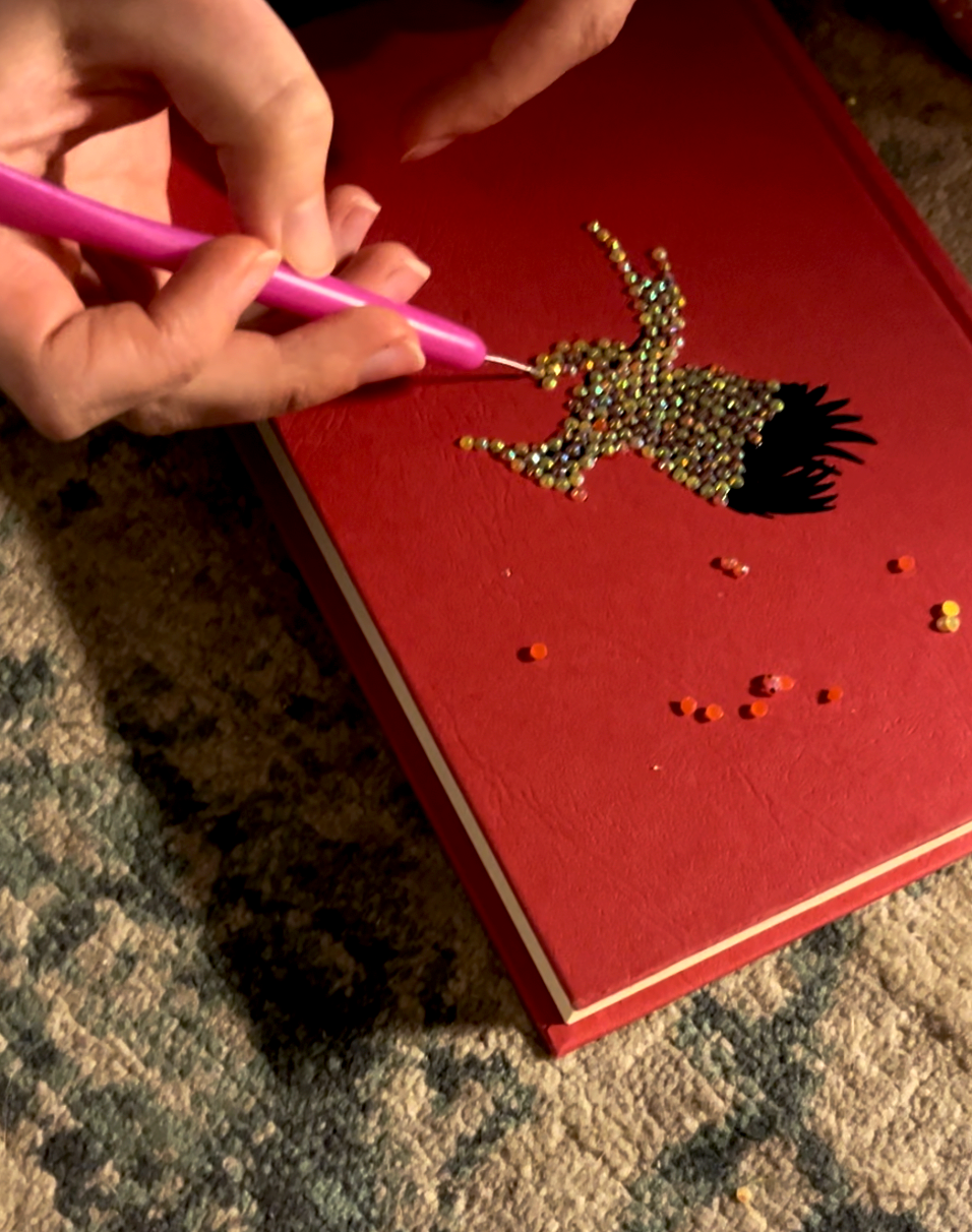 red book with gemstones diy craft using hands