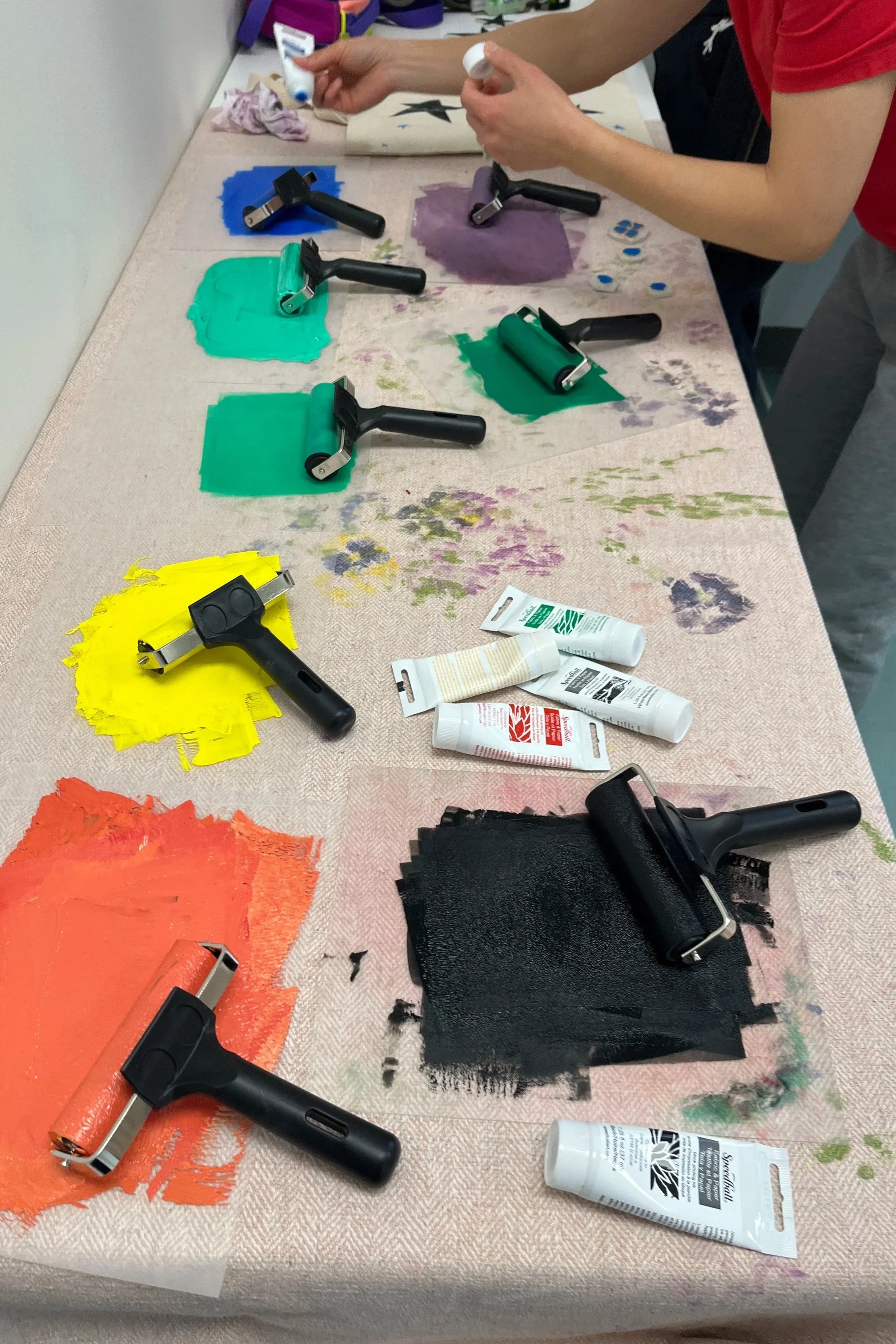 paint and brayers for block printing on table
