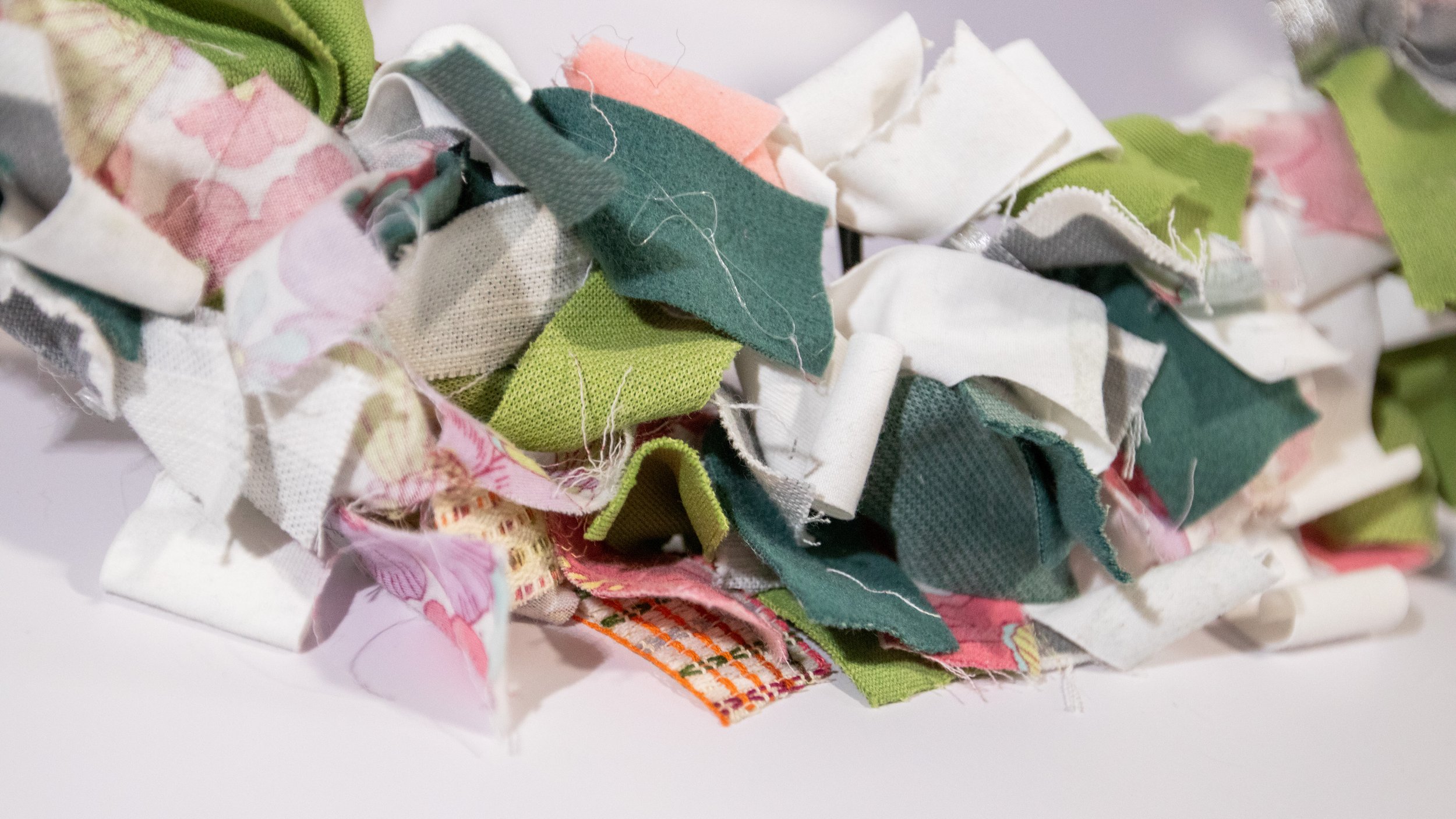 close up scrap fabrics tied to wreath frame in pink, white, green, floral fabrics