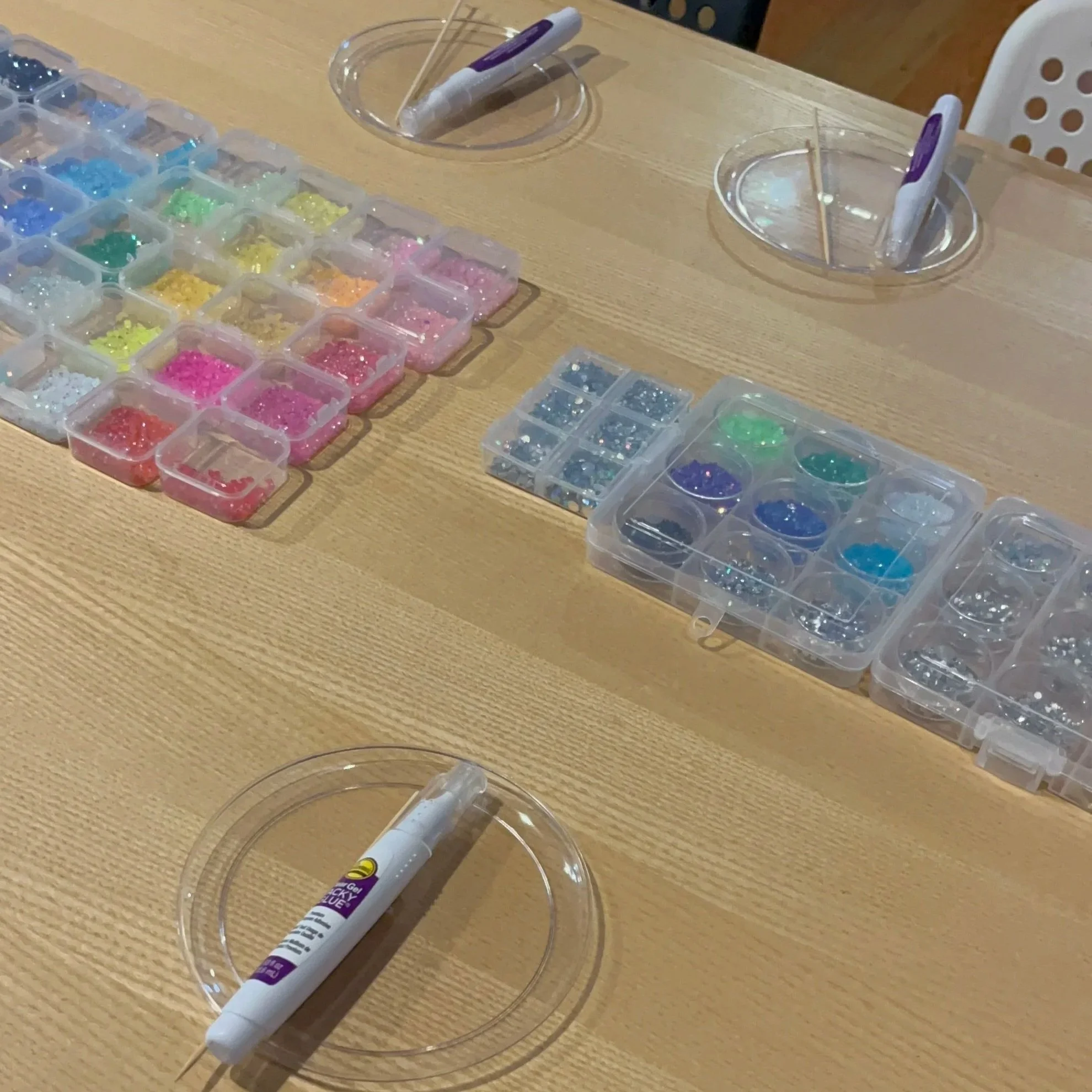 gems and glue pens on table for crafts