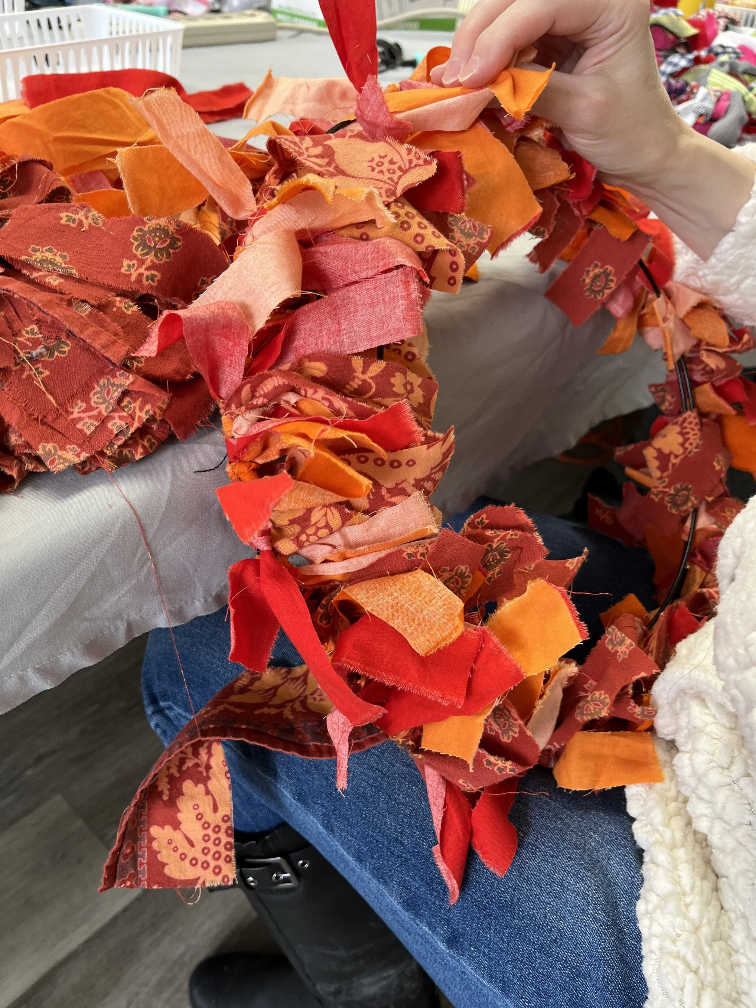 bright orange scrap wreath being made at a table