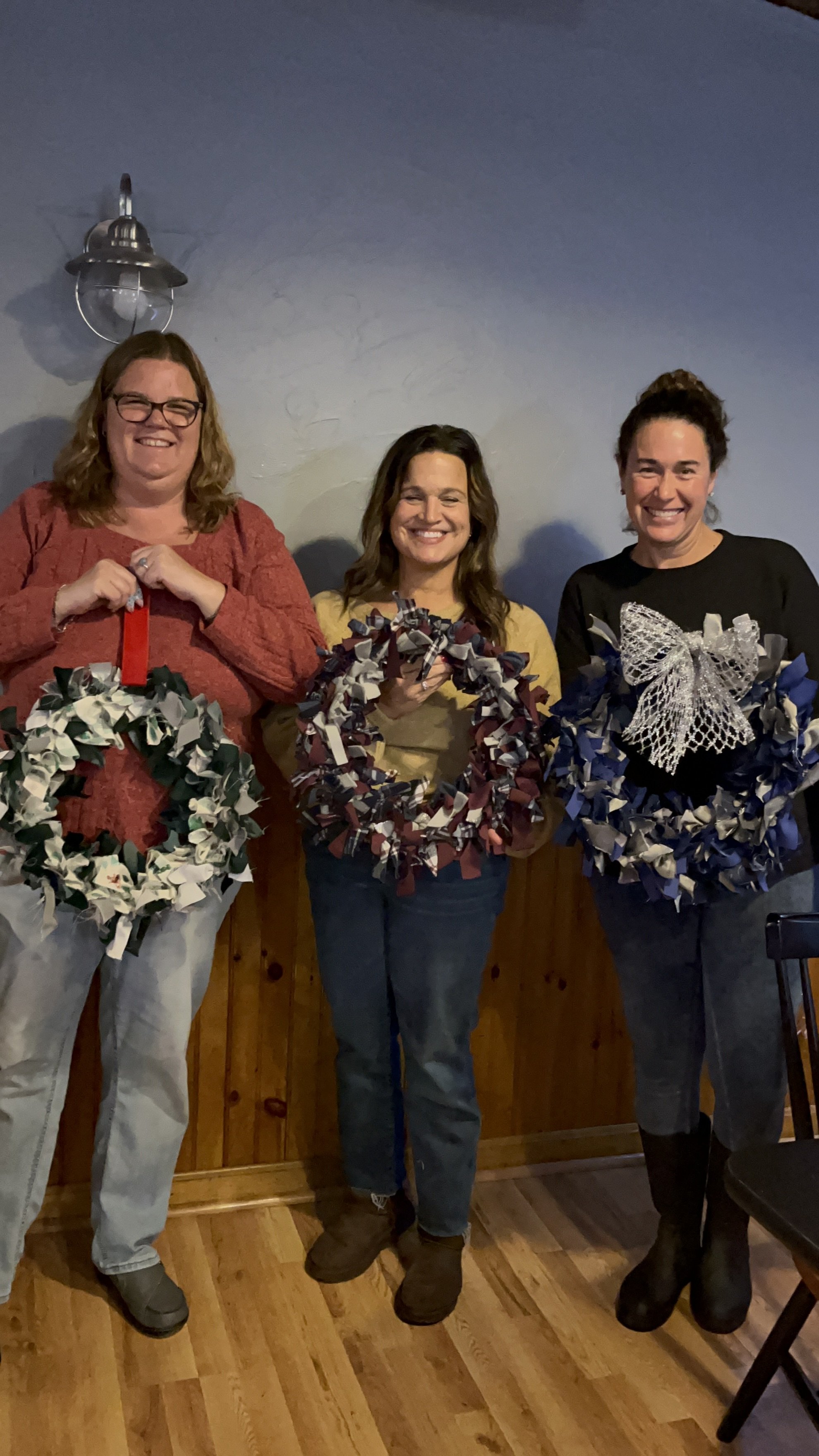 fabric wreath 3 people holding up their finished wreahts
