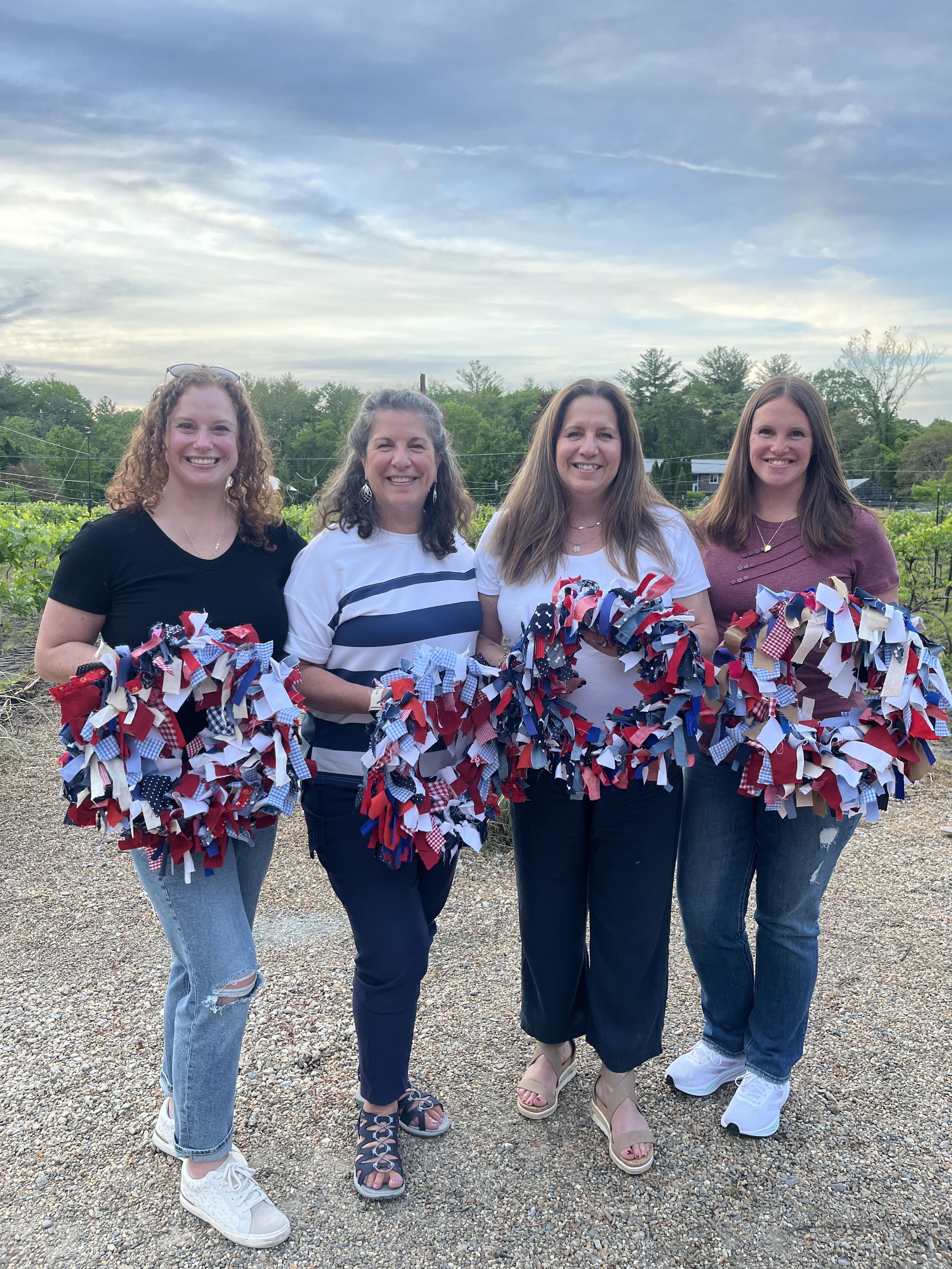 4 people holding  upcycled wreath outside