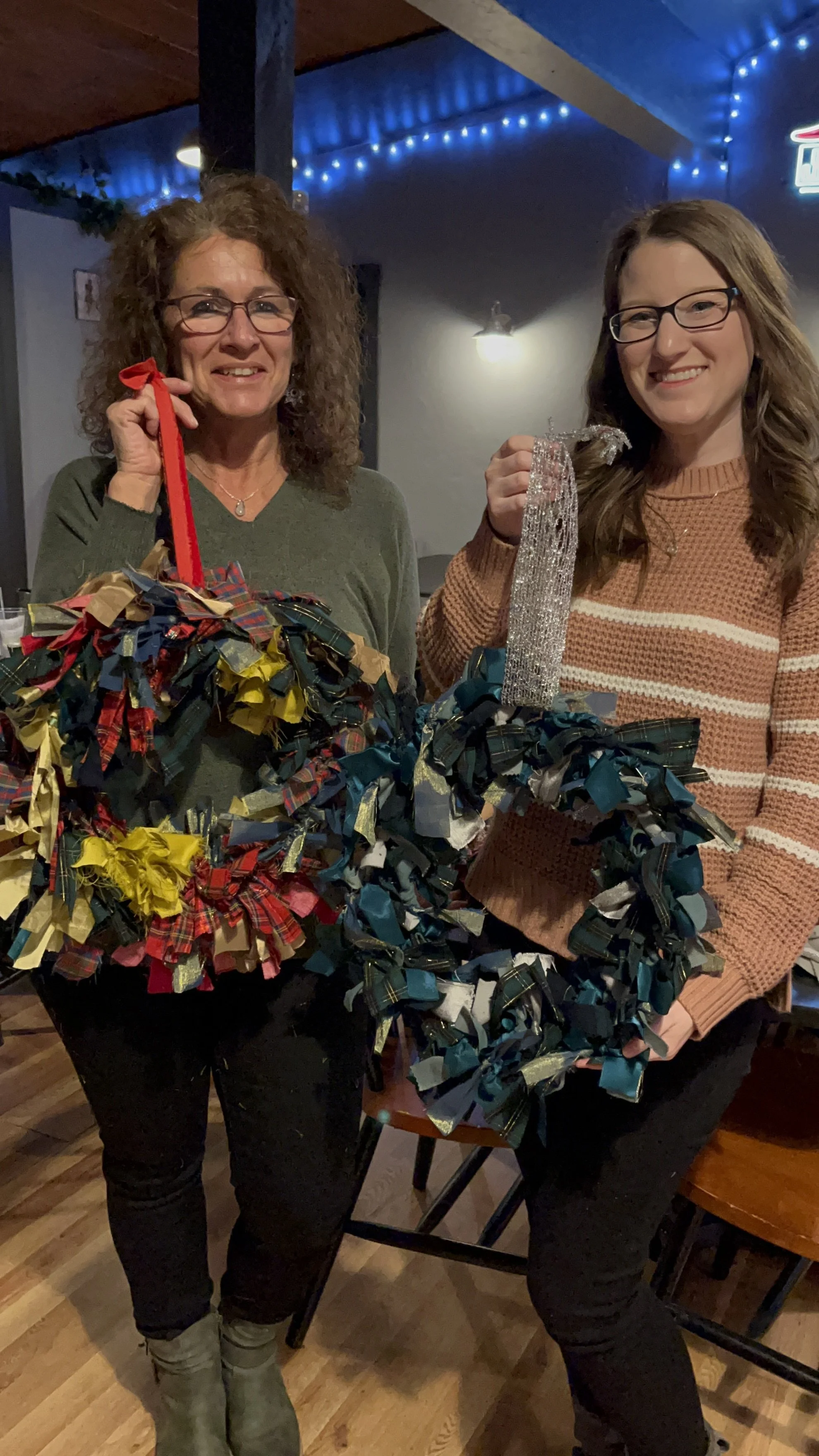 2 people holding  upcycled wreath