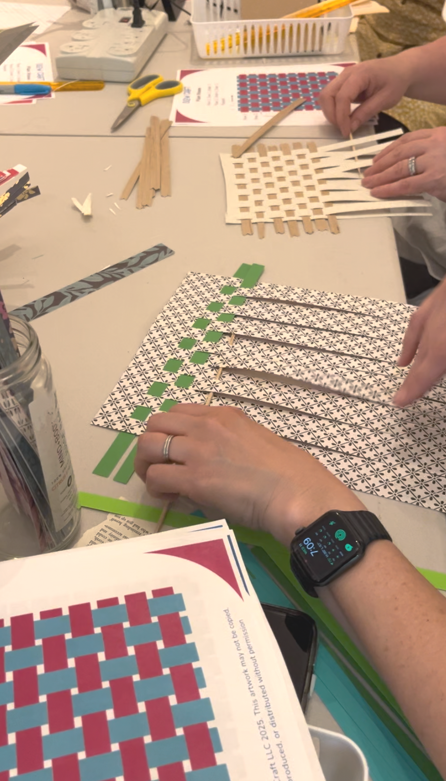 paper weaving pattern with green close up of hands at the table working