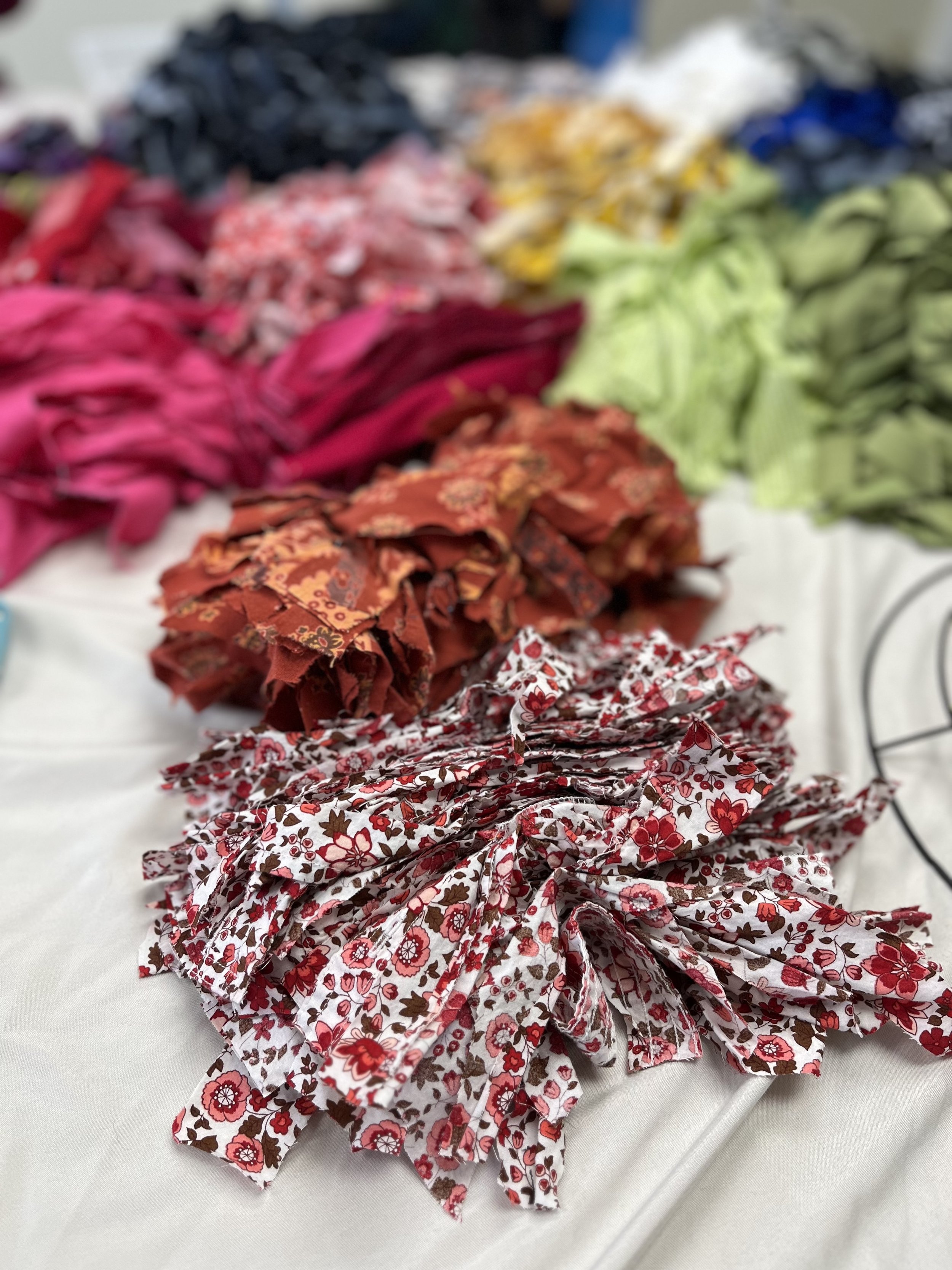 piles of fabric pieces for crafting DIY class workshop on a table