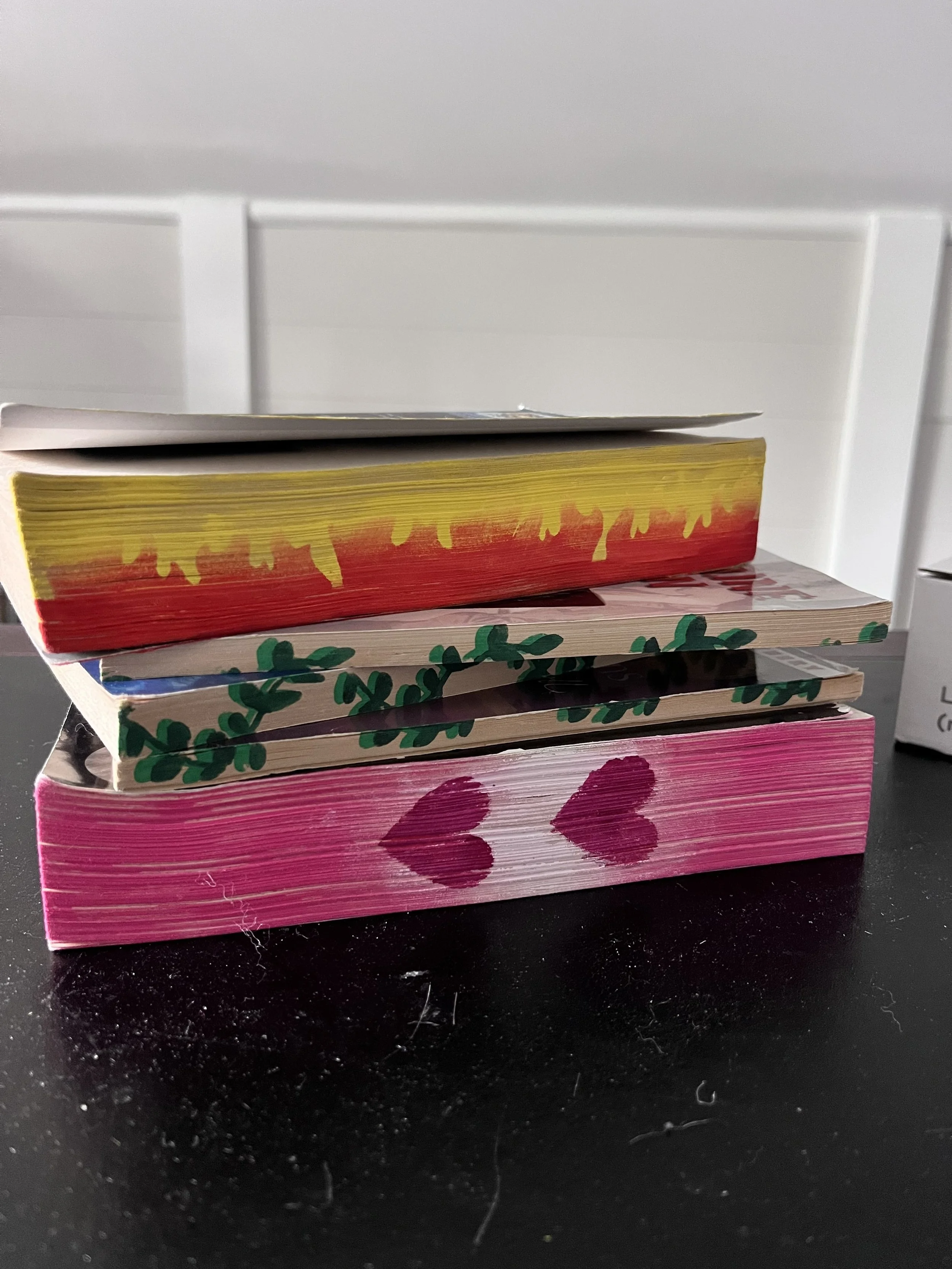 3 stacked books on table with stenciled pages