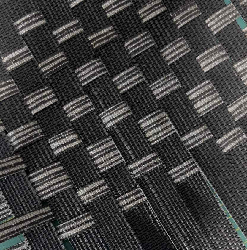Close-up of woven black and gray carbon fiber material in weaving class at Slow Craft Co in Nashua NH and Greater Boston MA adult creative craft art classes and workshops team building