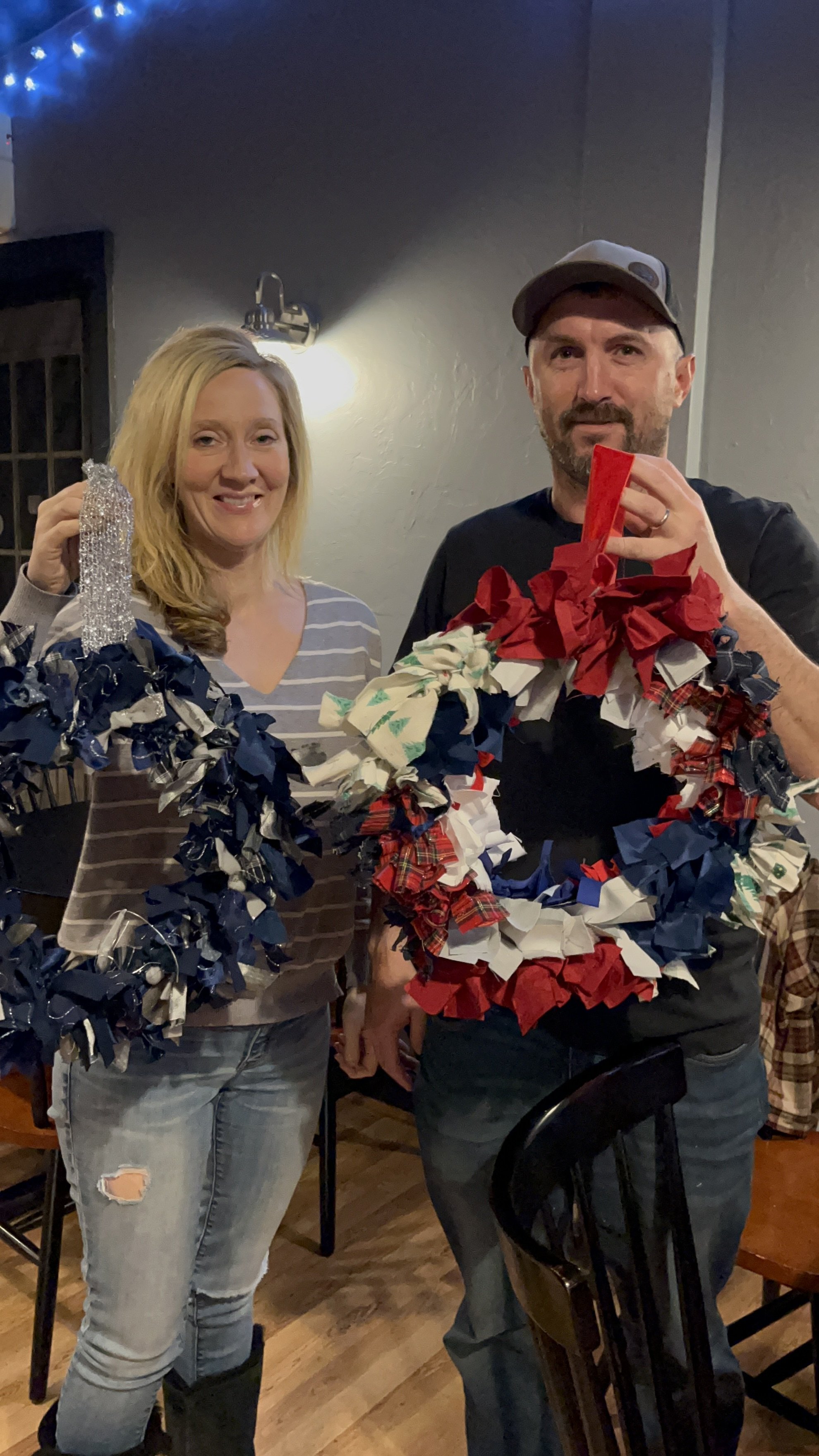 2 people holding  upcycled wreath