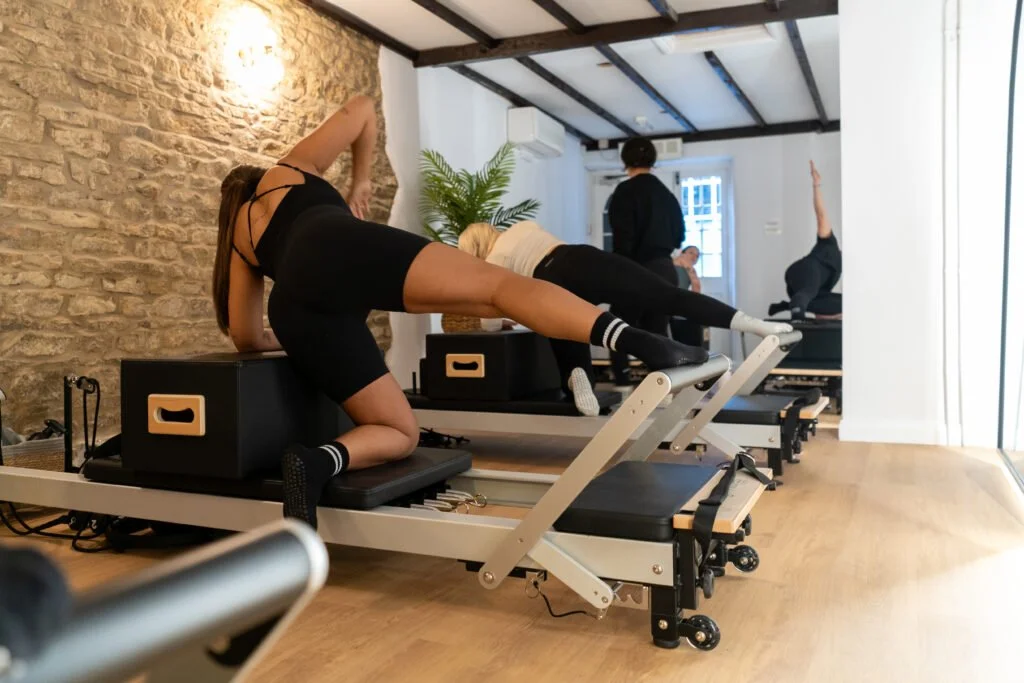 Pilates studio members taking part in a group Reformer Pilates class