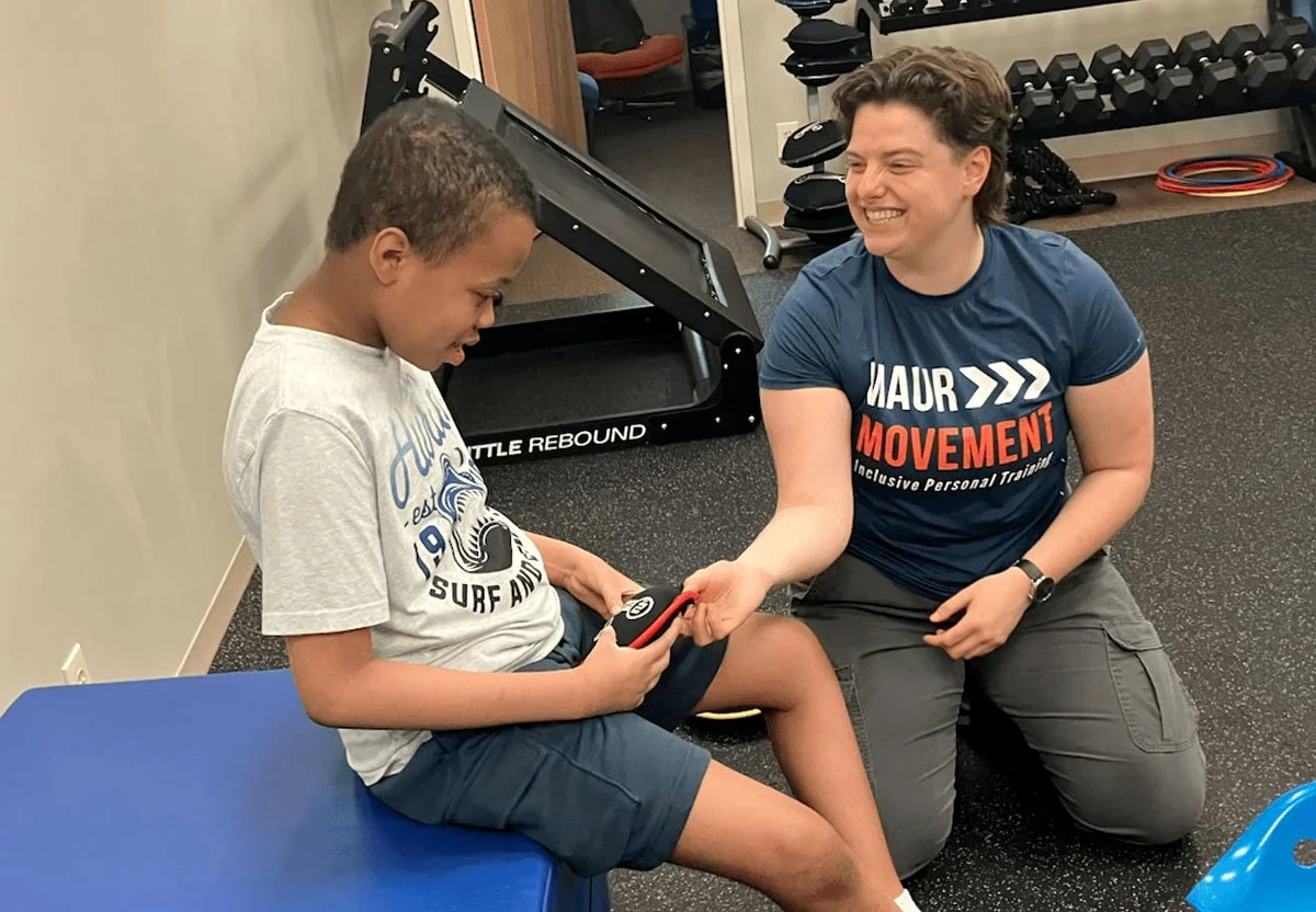 adaptive trainer working with student in special needs gym