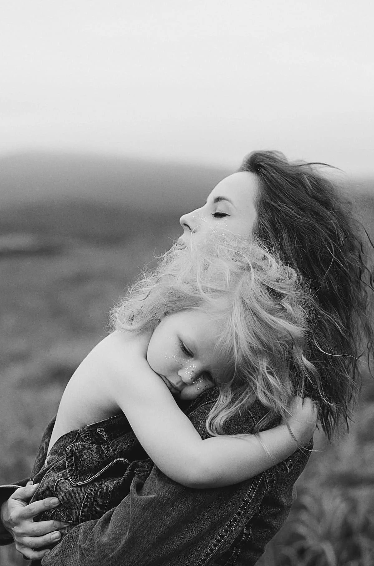 Black and white photo of a mother holding her young child close, the life stage a mommy makeover in Denver is designed around