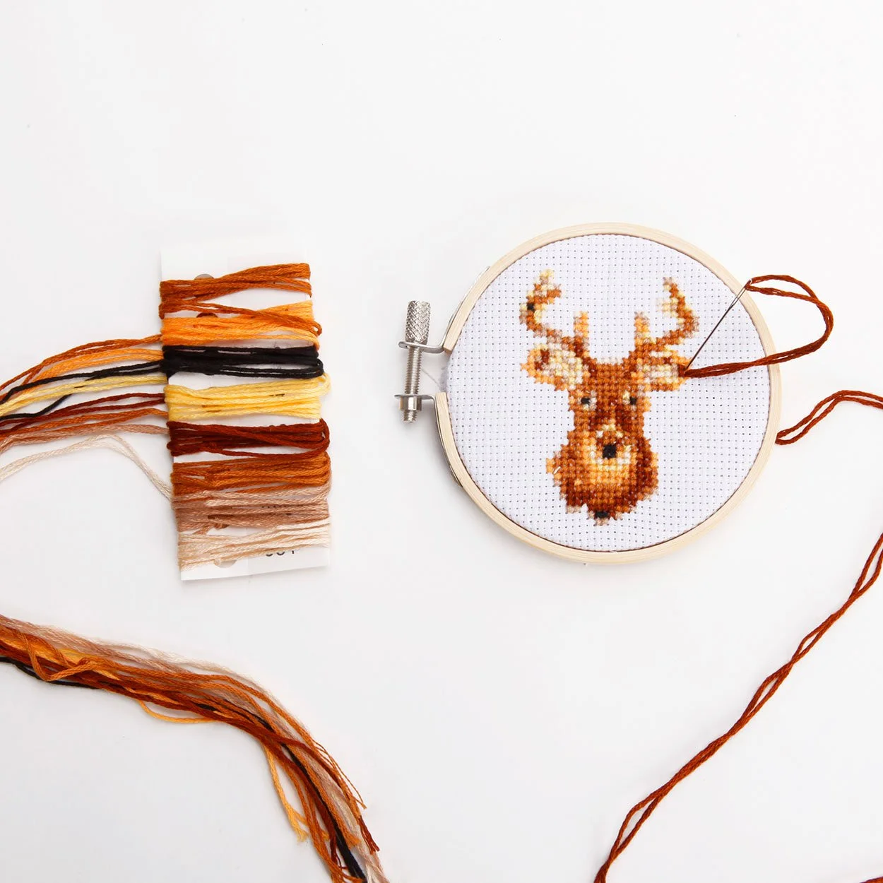 Mini deer head cross stitch in bamboo hoop with brown color thread card on white background