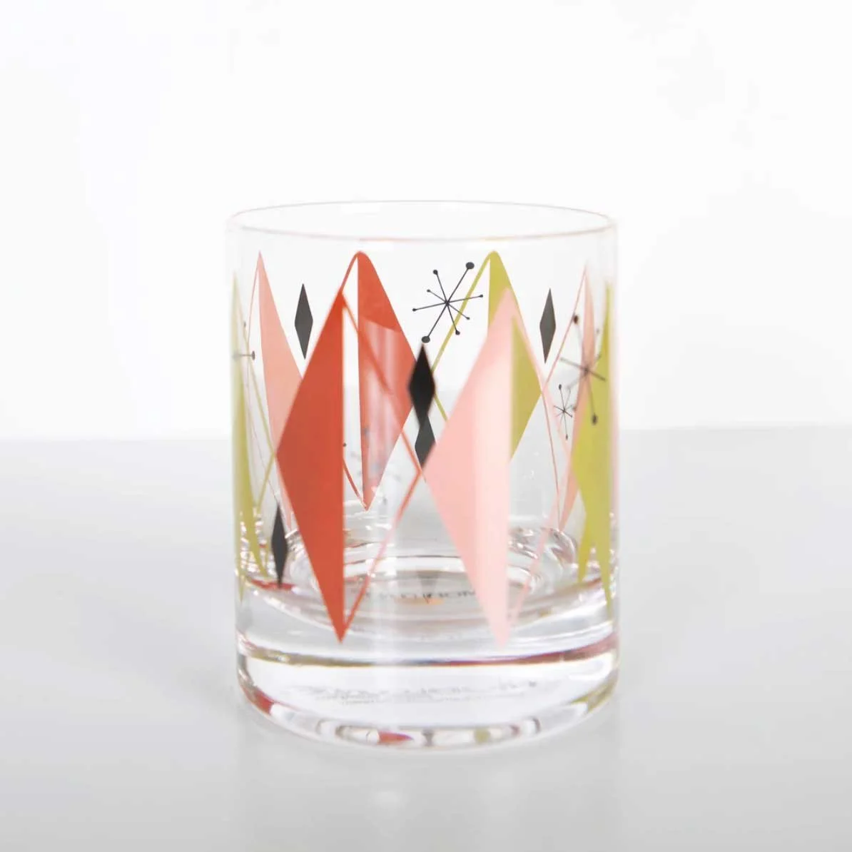 Single retro vintage diamond starburst rocks glass with red, pink, and green pattern on white background