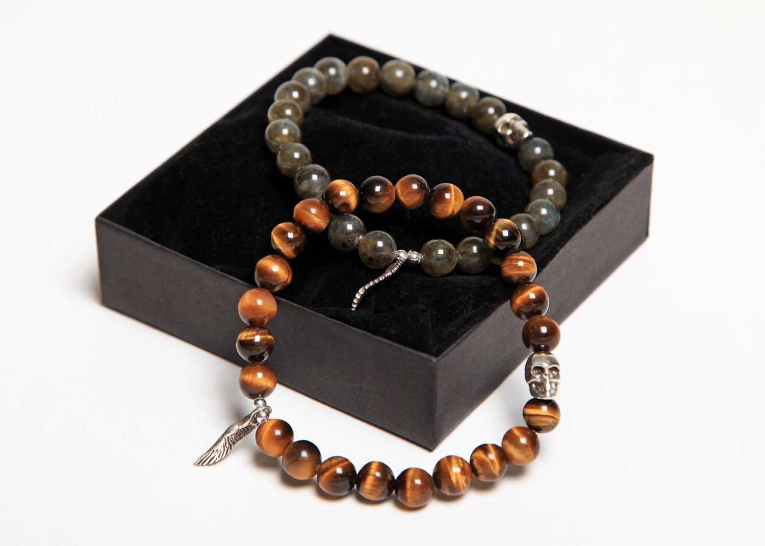 Display of custom-designed bracelets with onyx, Tiger’s Eye, and other gemstones, featuring skull charms.