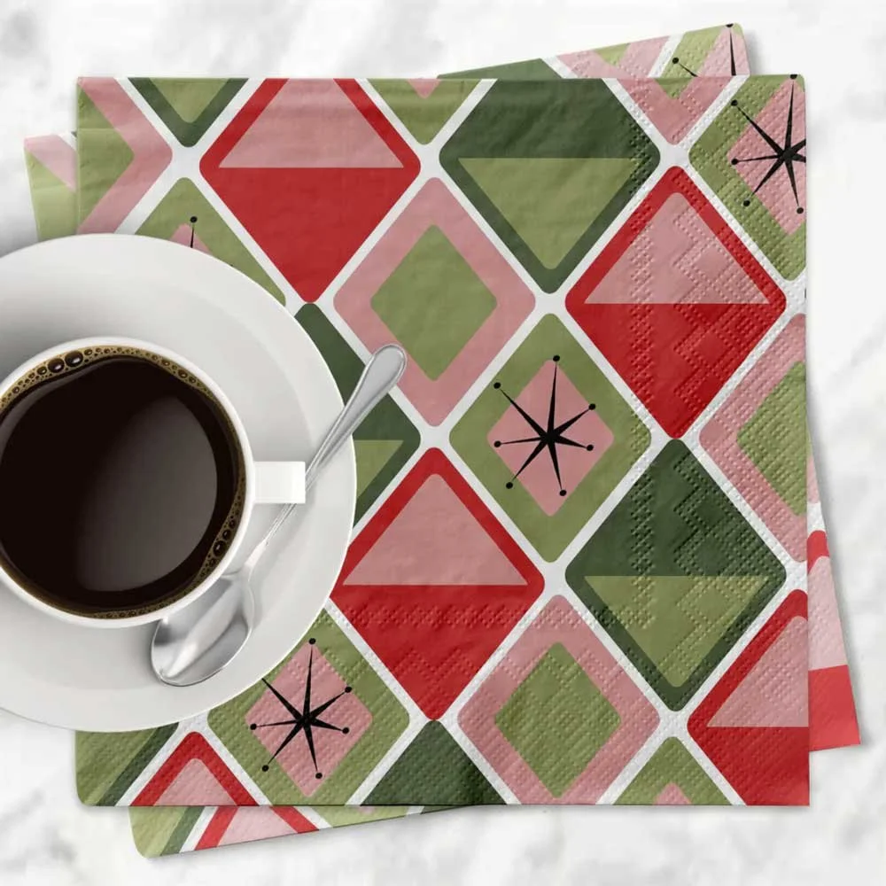 Mid-century modern diamonds holiday cocktail napkin with a retro geometric print in pink, red, and green styled with a white coffee cup and saucer