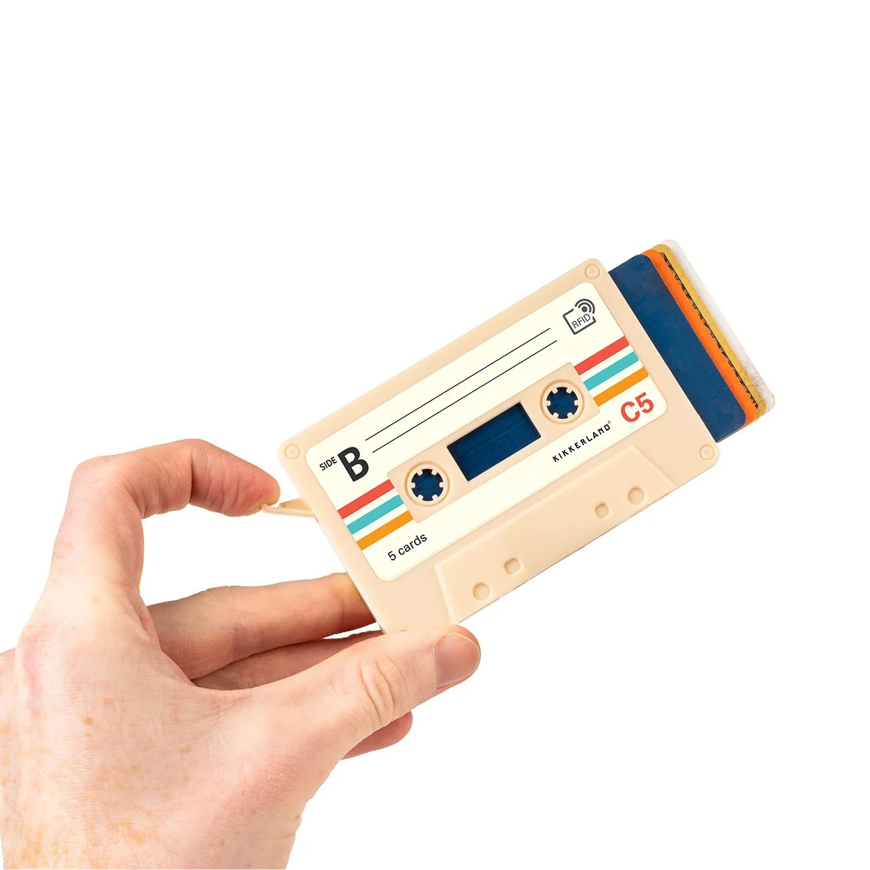 Hand holding cream cassette tape card holder with credit cards fanned out on white background