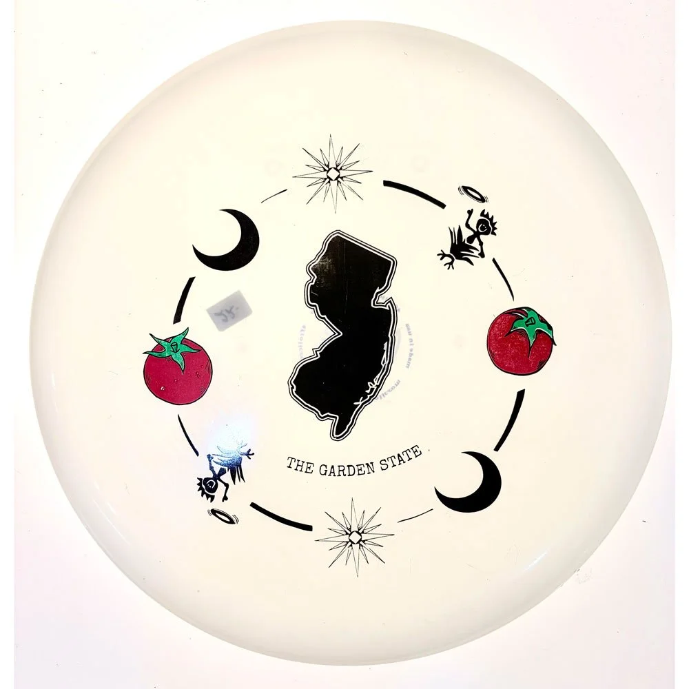 White glow frisbee with black New Jersey state map, tomatoes, moons, and The Garden State text in center