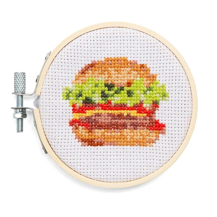 Completed mini burger cross stitch in a bamboo hoop frame on white background