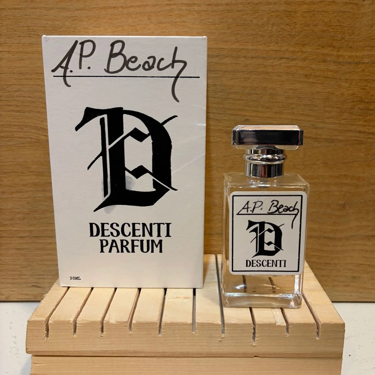Descenti Parfum A.P. Beach 30ml eau de parfum bottle with box on warm wood background