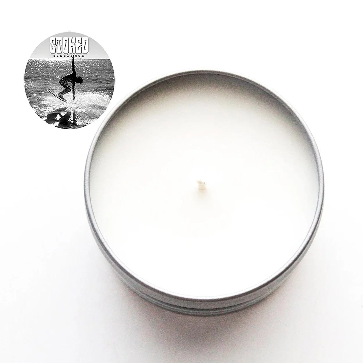 Top view of unlit Stoked Candle The Beach soy candle in silver tin showing white wax surface and cotton wick