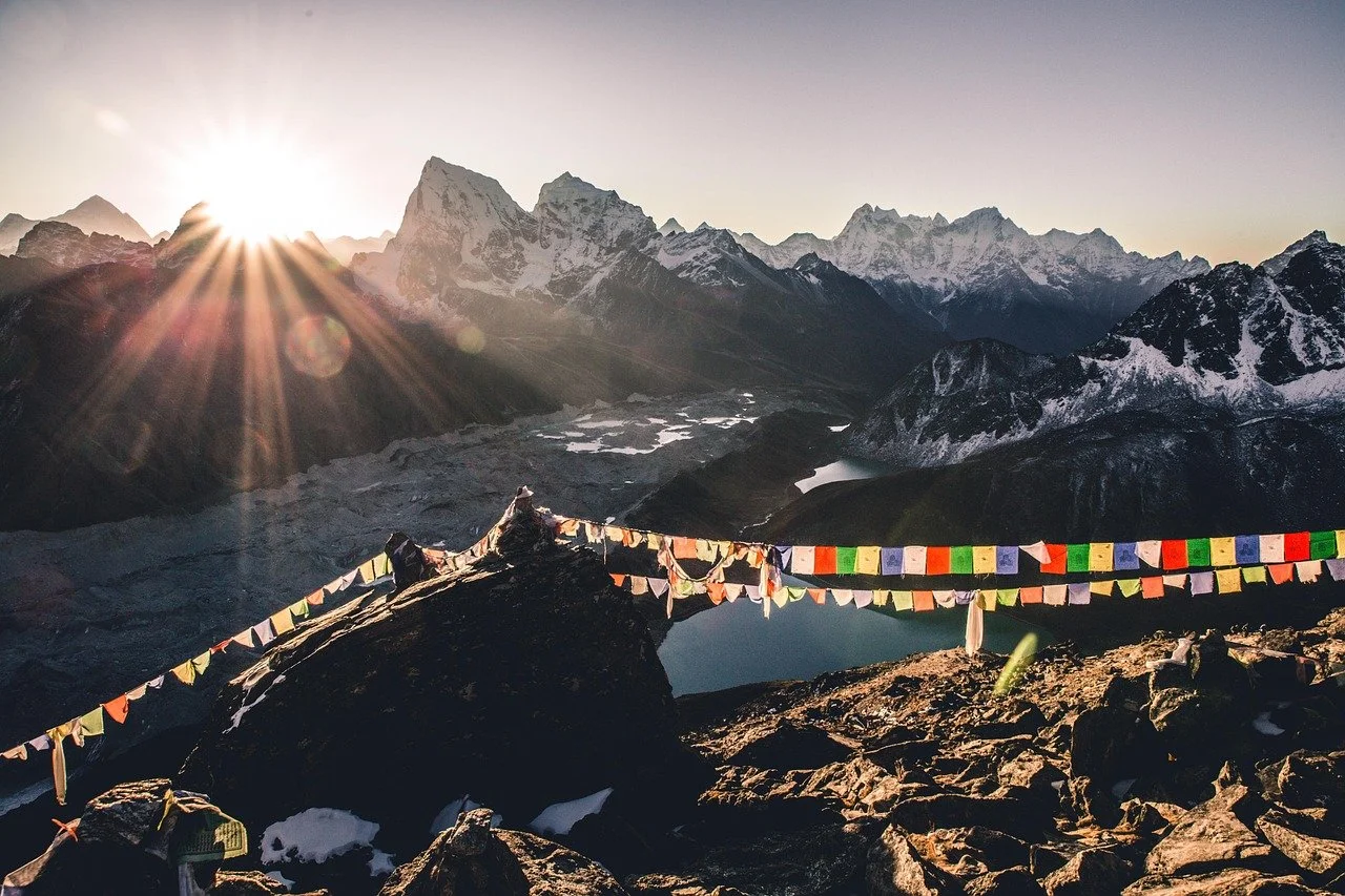 Mountain landscape during sunrise with prayer flags in the foreground