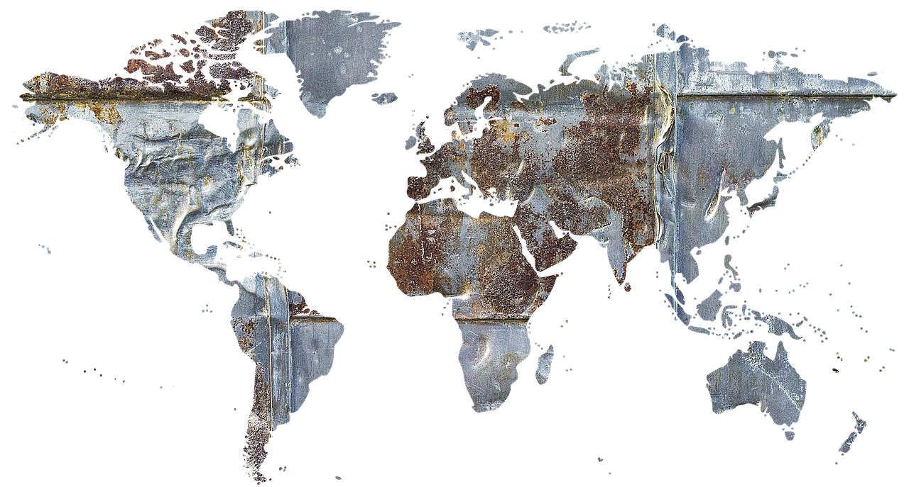 A rusted, weathered world map made of metal with visible corrosion and chipping paint.