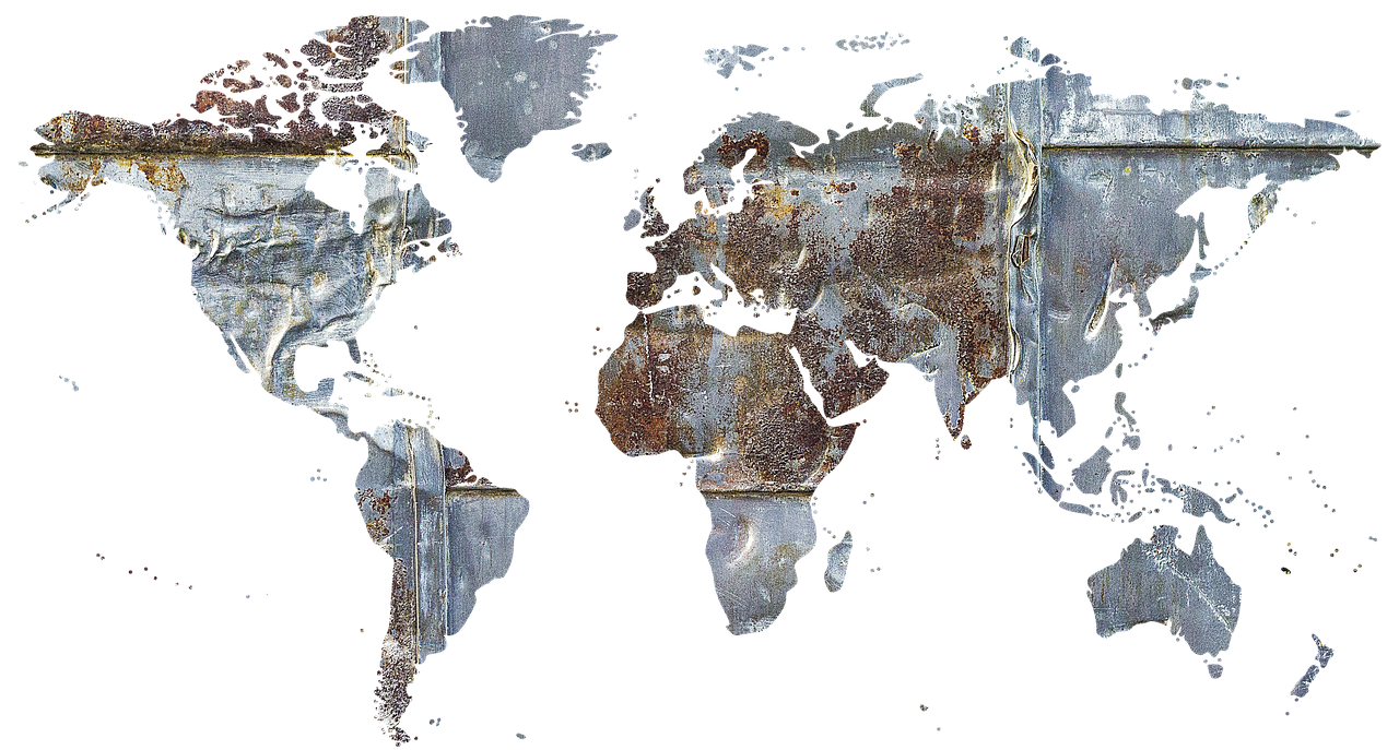 A rusted, weathered world map made of metal with visible corrosion and chipping paint.