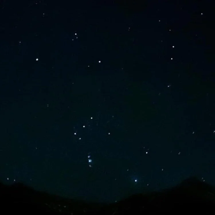 A dark night sky scattered with stars, including the constellation Orion, seen from Iceland.