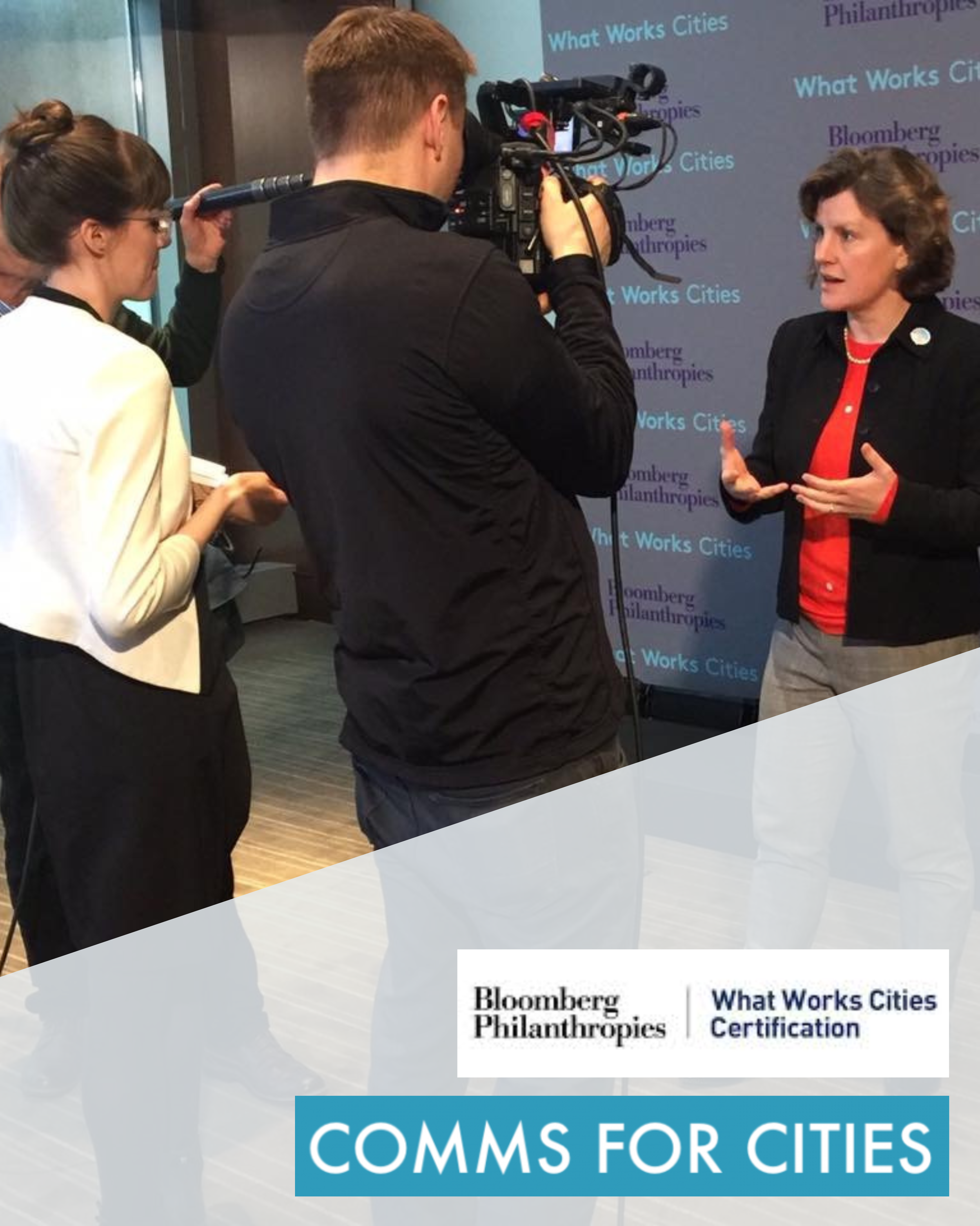 Kristin (a white brunette woman) interviews a mayor (a middle-aged white woman) standing in front of a branded step-and-repeat. A white camera man stands between them, recording the interview. Atop the image is the text Comms for Cities.
