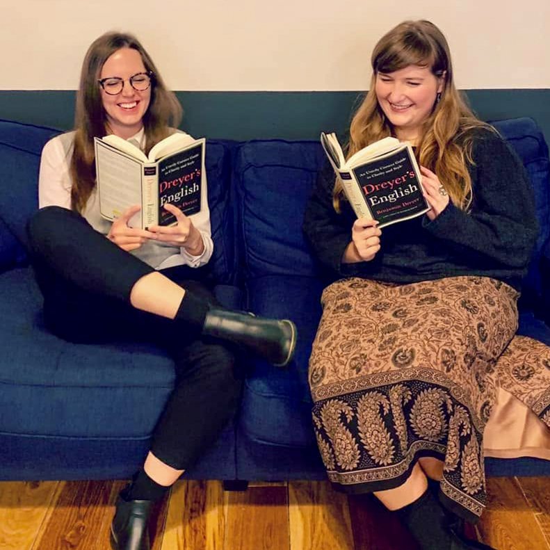 (Right) Kristin and a woman colleague sitting on a couch, smiling while reading copies of Dreyer’s English.