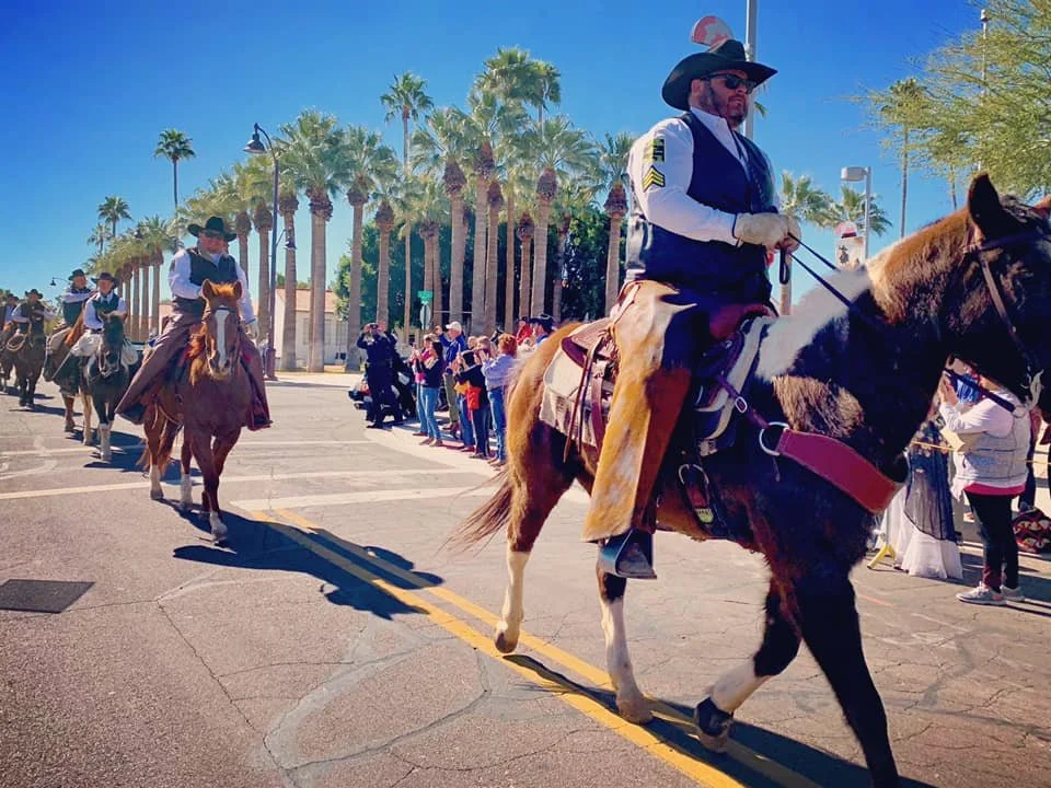 Men on horses make their way down the street in the final leg of the Pony Express in Scottsdale, Arizona
