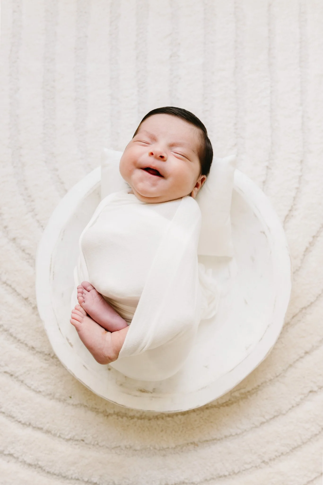 A beautifully posed and swaddled newborn captured during a studio session in Palm Beach. Julie James Photography specializes in soft, classic newborn posing with an editorial touch.