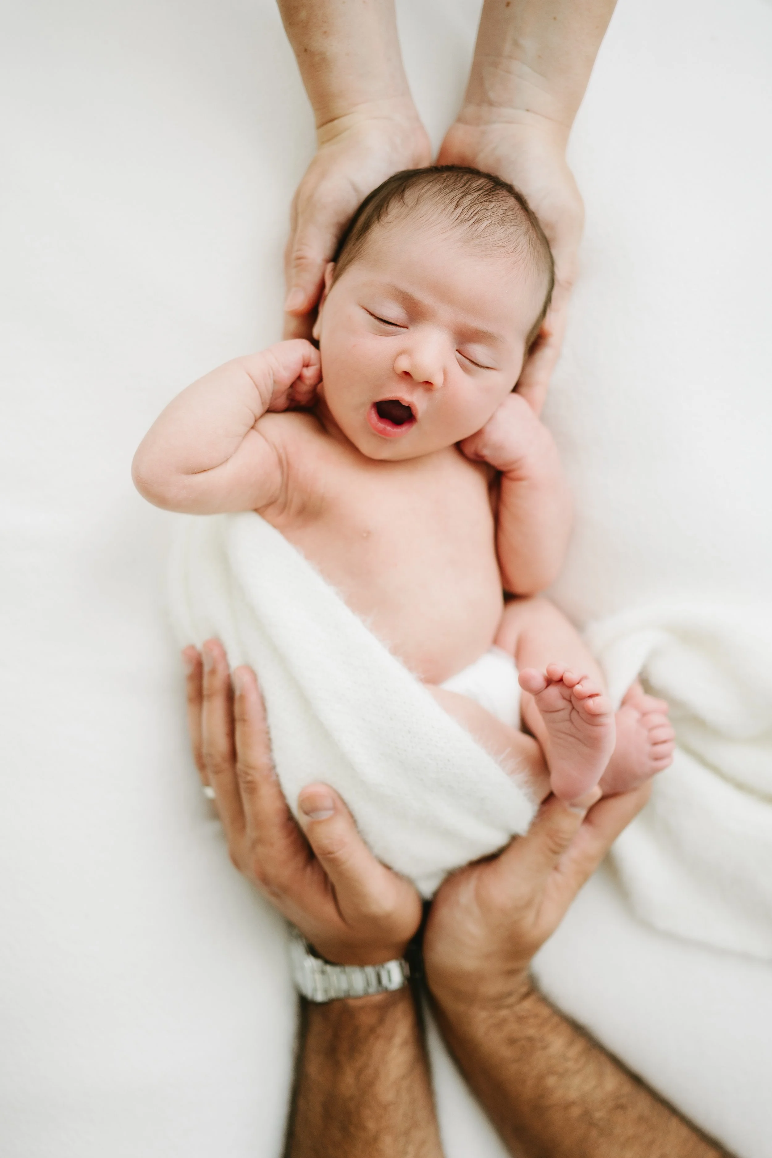A newborn sleeping peacefully during light and airy newborn studio session capture by South Florida newborn photographer Julie James photography.