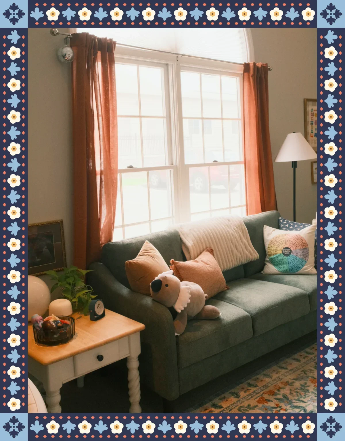 Cosy therapy office with a sofa, plants, warm lighting, and a large window.