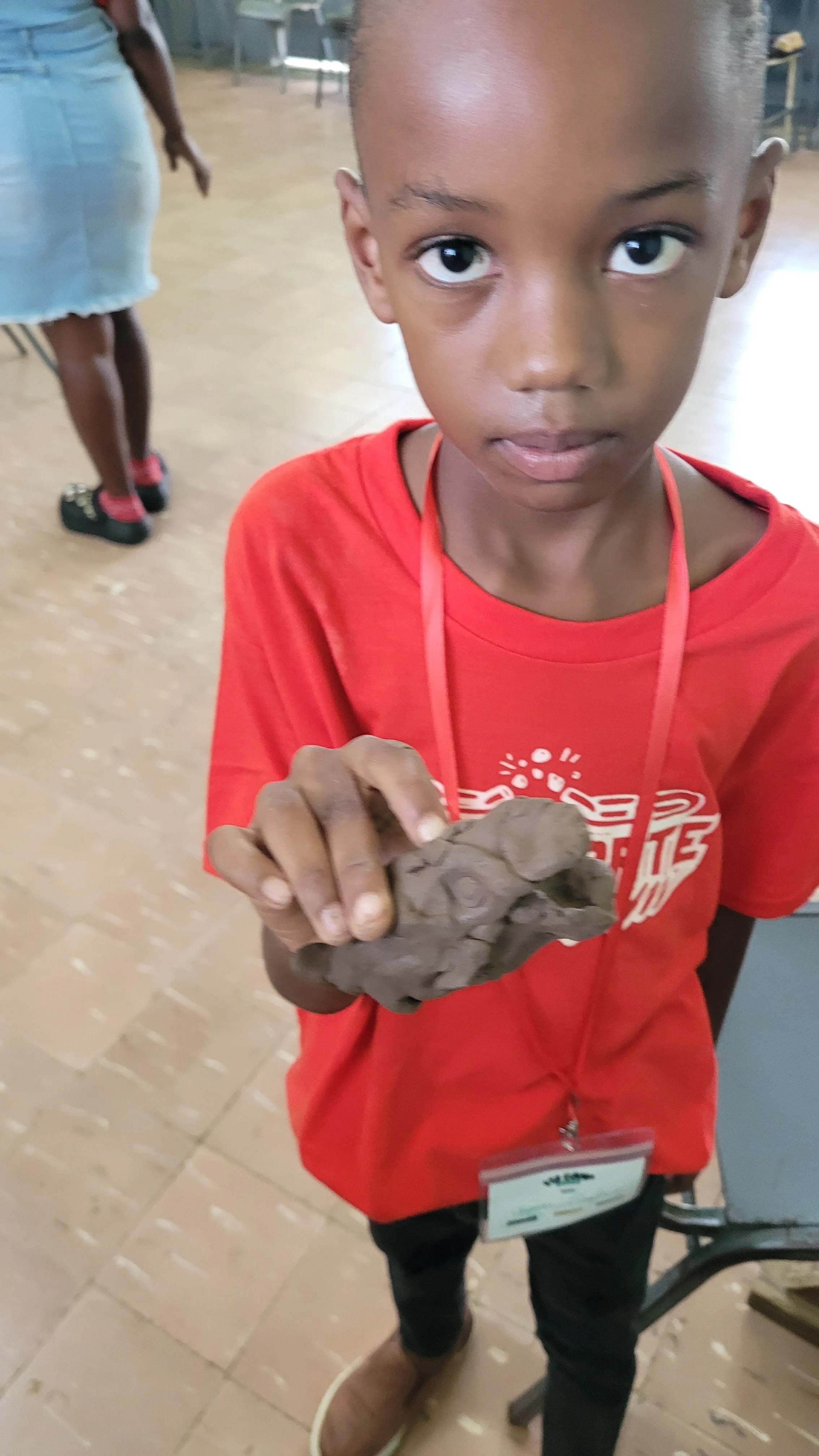 child displaying his clay work @ FSF camp 2025