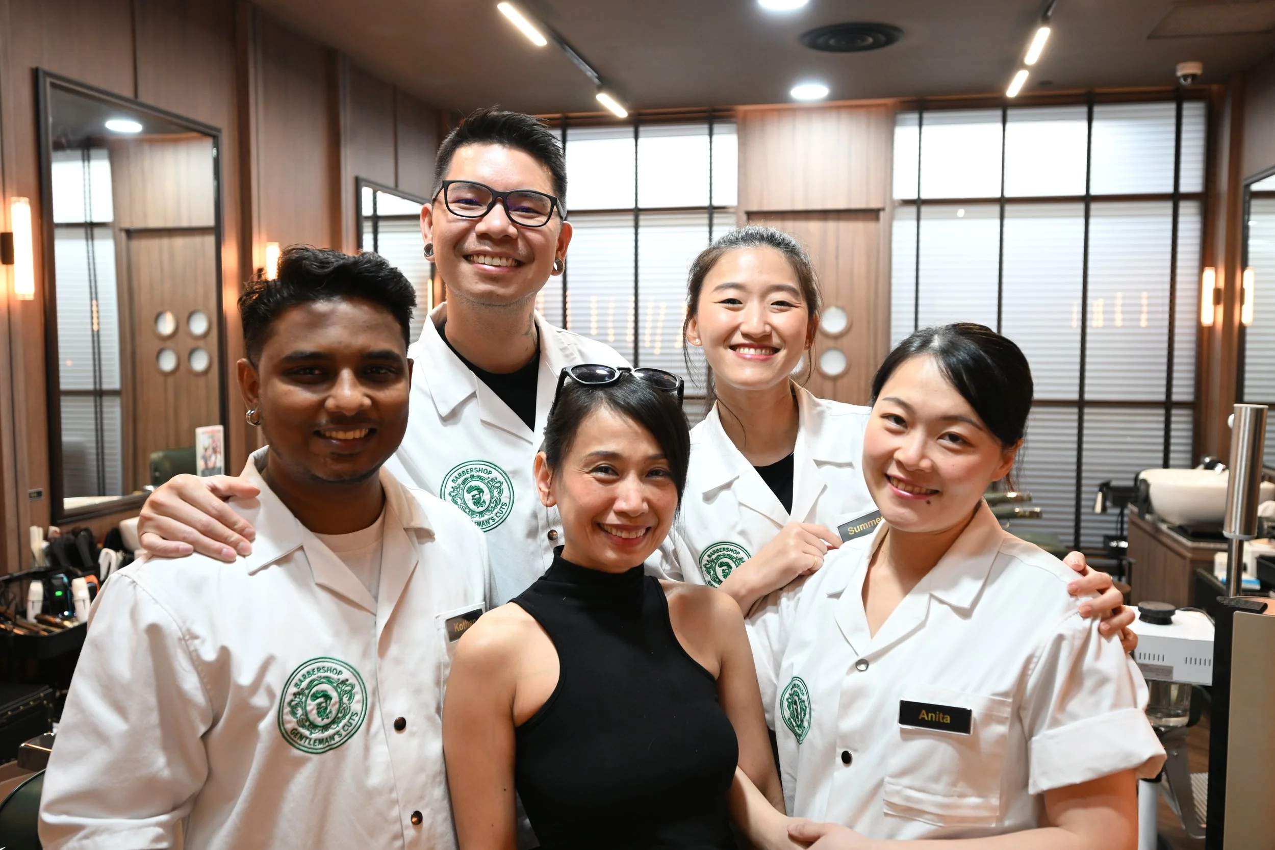 Barbers and client smiling at Gentleman’s Cuts Singapore, showcasing the friendly and professional team