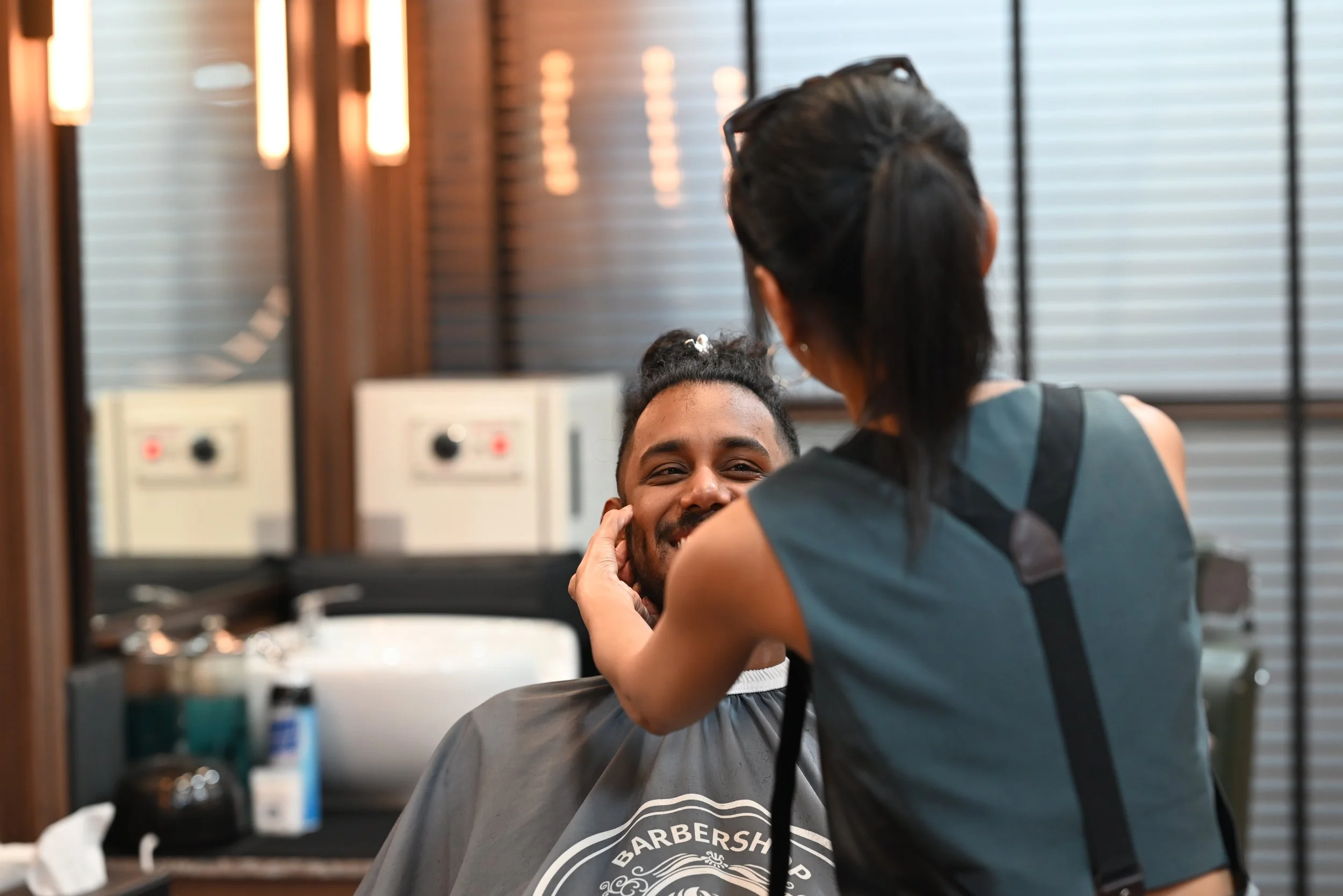 A clean shave, a cheeky grin, and a barber trying not to laugh along — grooming meets giggles. 