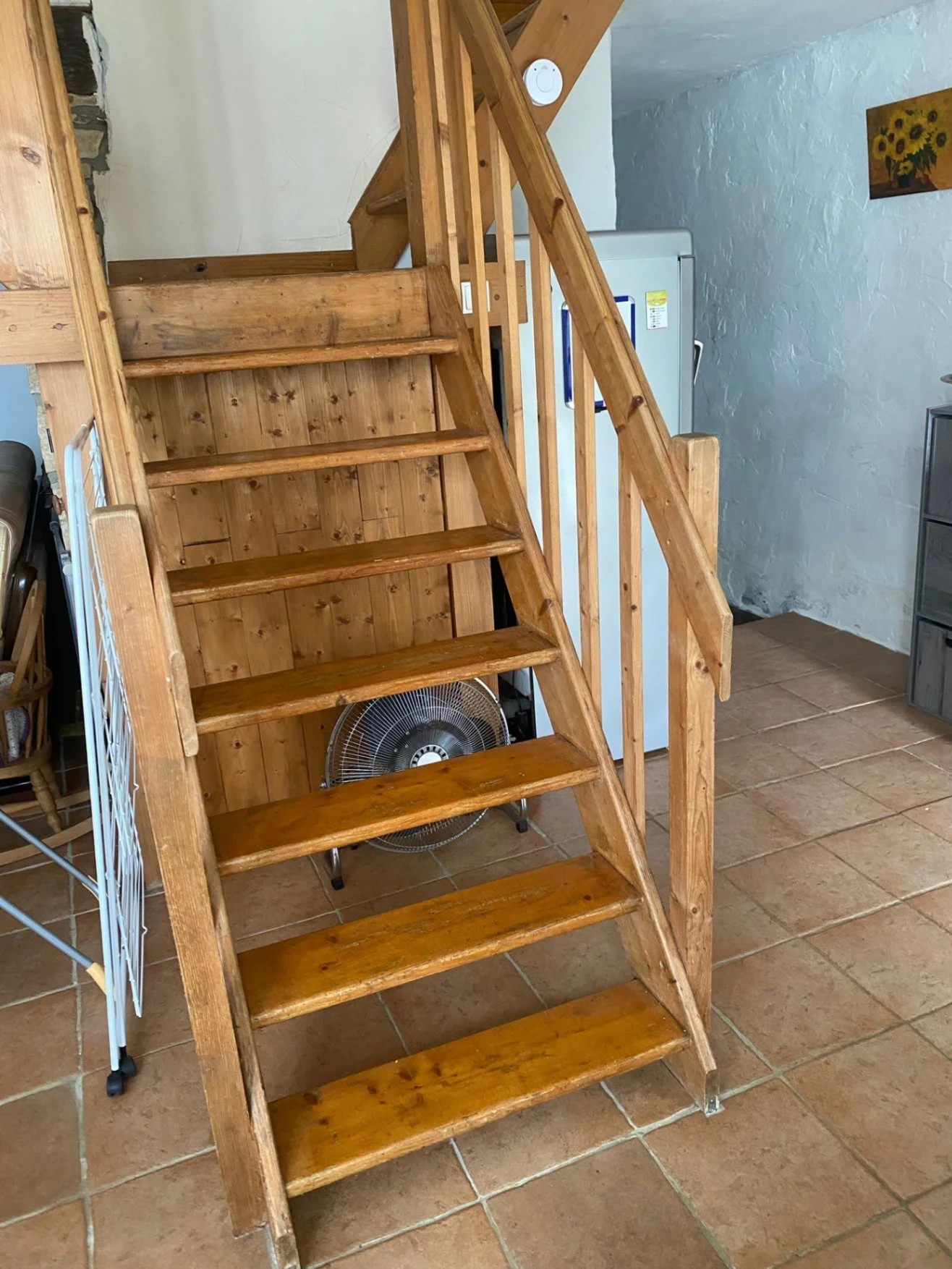 Wooden stairs with large gaps and handrail on either side