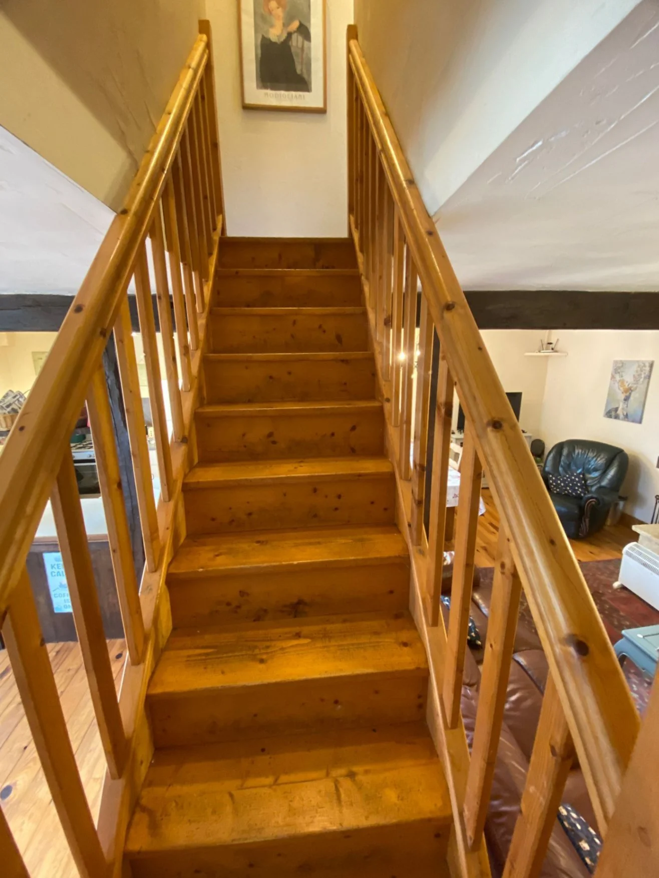 Main wooden stairs leading up to bedrooms and bathrooms handrails on both sides