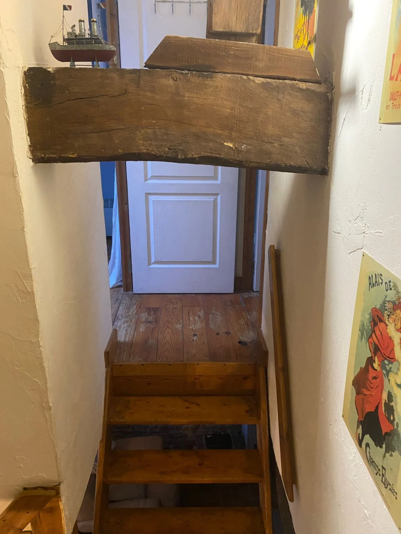 low beam across the top of the wooden stairs on bedroom and bathroom approach