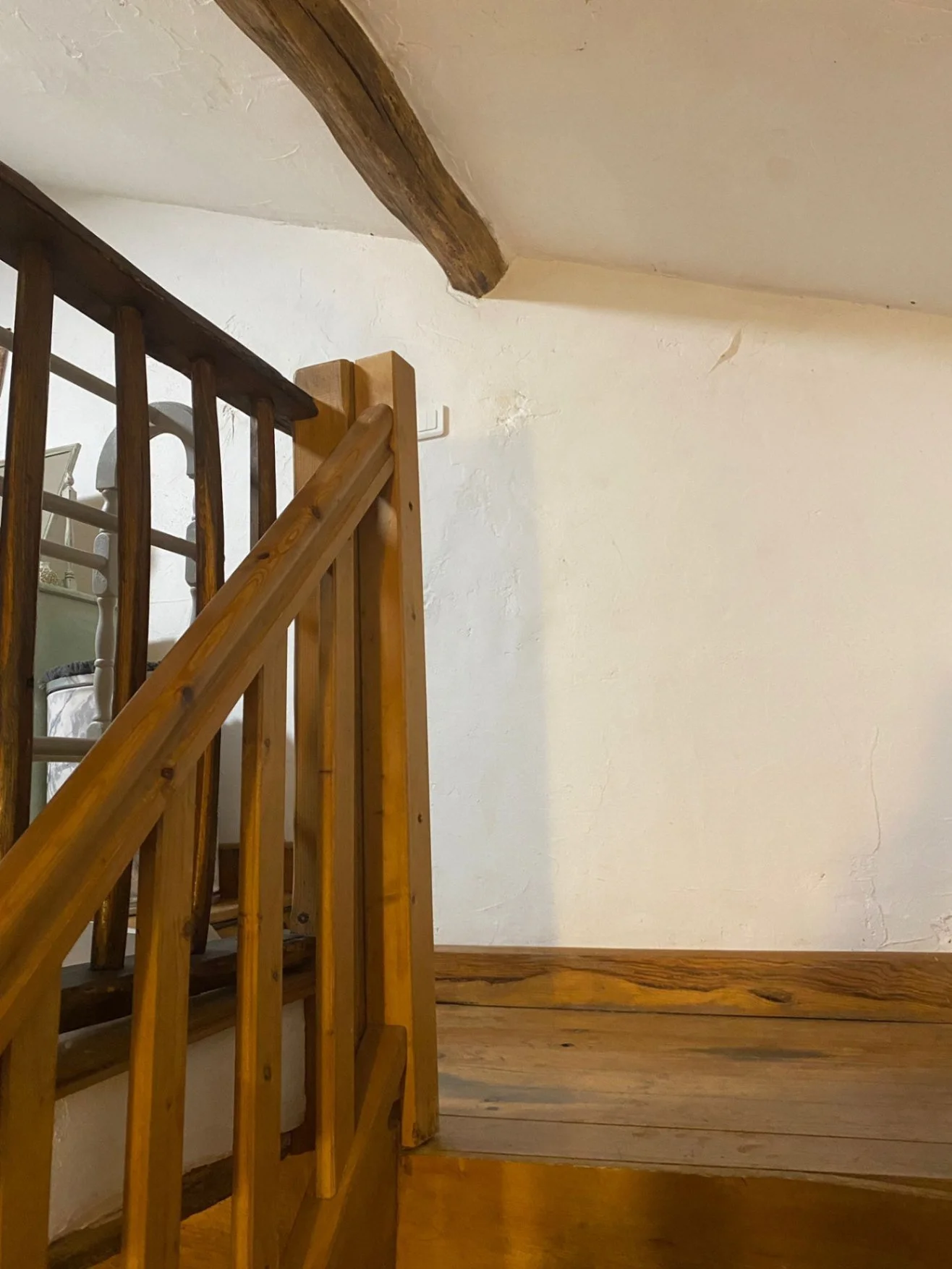 low ceiling and beam at top of wooden stairs