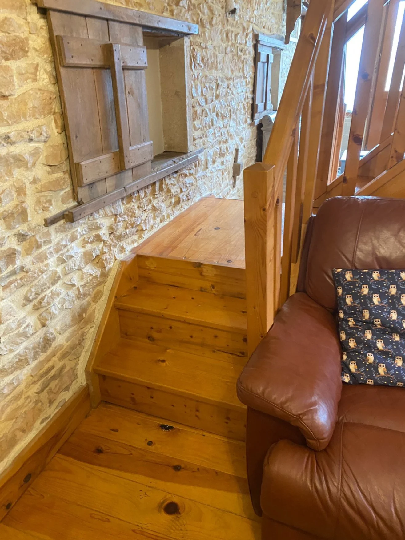 Three wooden steps leading to a flat platform at the base of main stairs. Handrail on right