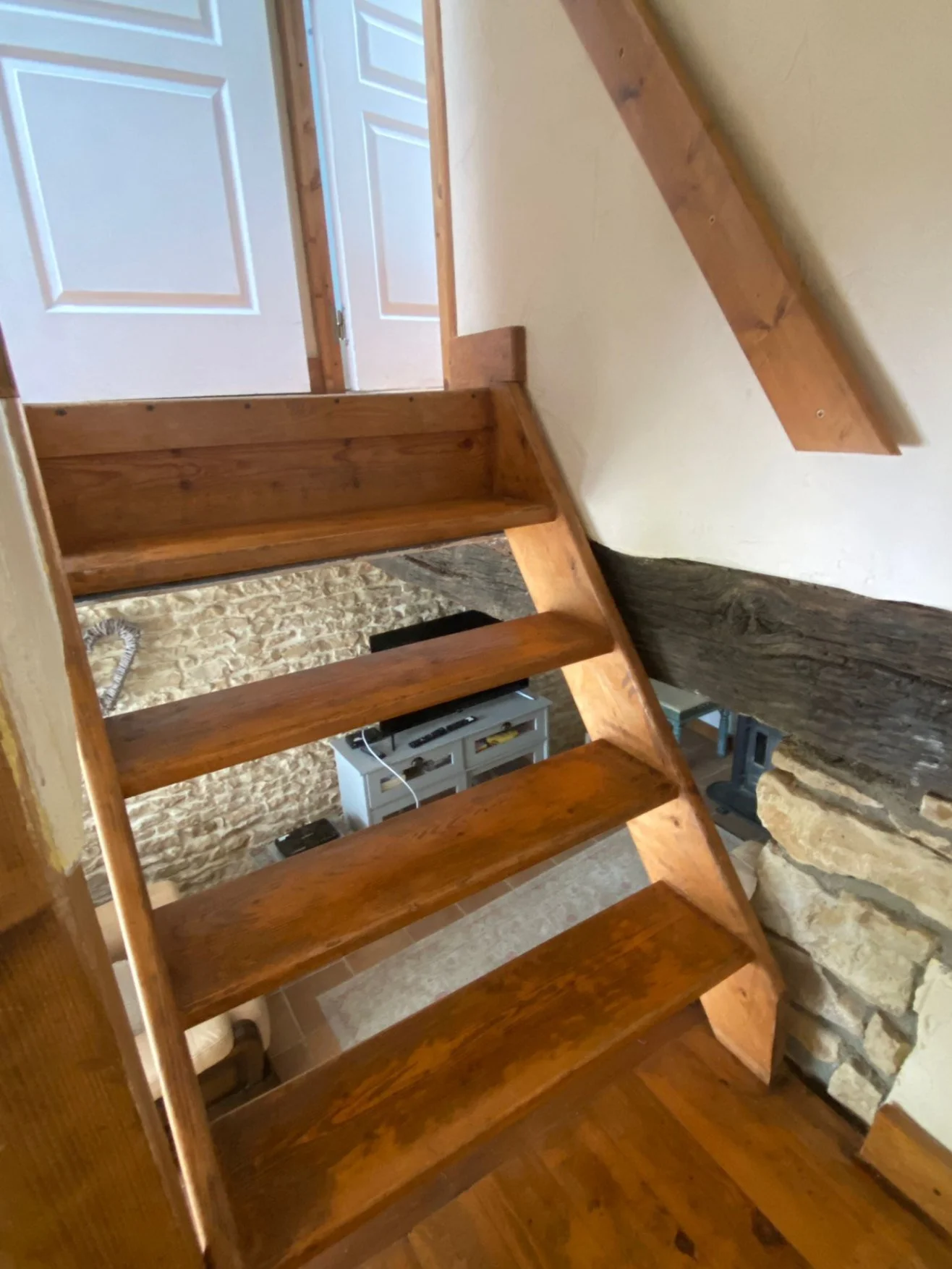 wooden stairs with large gaps and handrail on right hand side