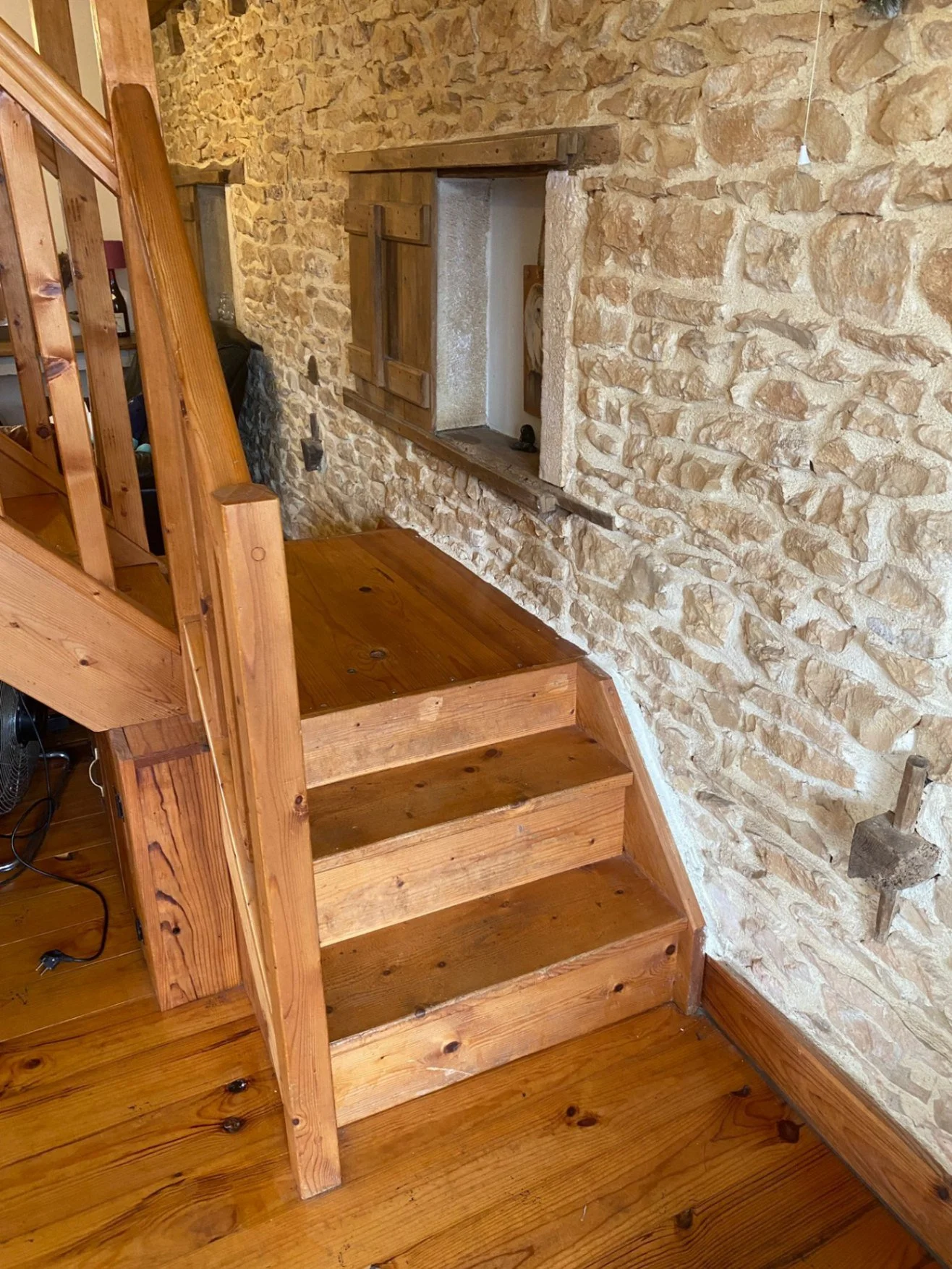 Three wooden steps leading to a flat platform at the base of main stairs. Handrail on left.