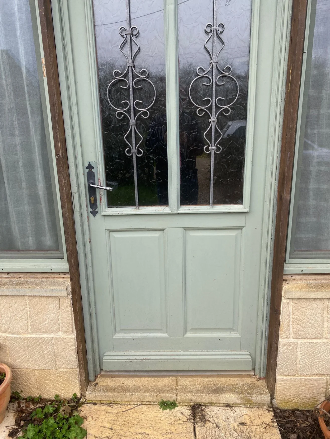 Small wooden step with two small layers at base of front door