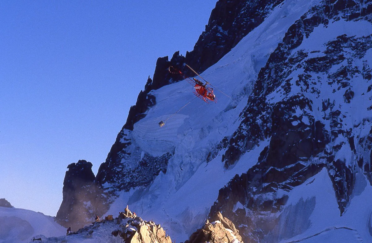 Mid-80s: I was bivouacked on the porch of the old Cosmiques hut at the Col du Midi. They were pouring the foundation for the new hut, flying concrete up to 3800m one bucket at a time.