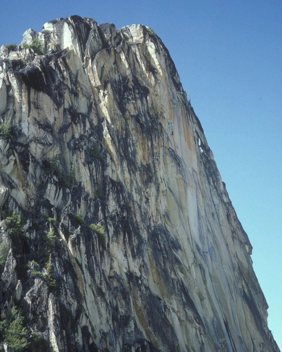 1987: East Face of South Early Winter Spire in the North Cascades. The splash or white in the upper right corner of the face is a paraglider attached to Jonny Blitz who took an early downwind turn coming off the summit, lost control in the rotor and